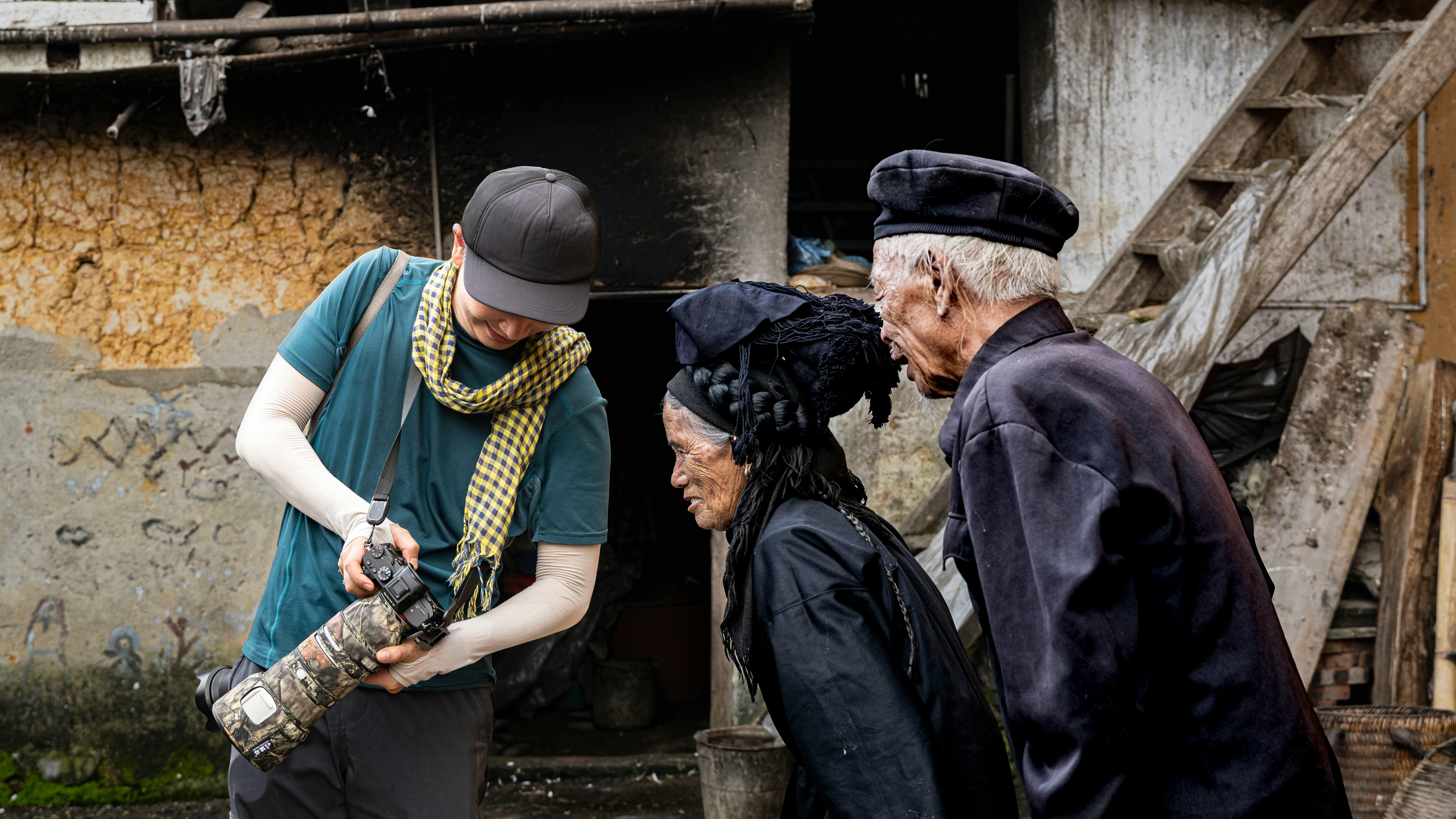 A Photographer Showing the Photos to an Elderly Couple