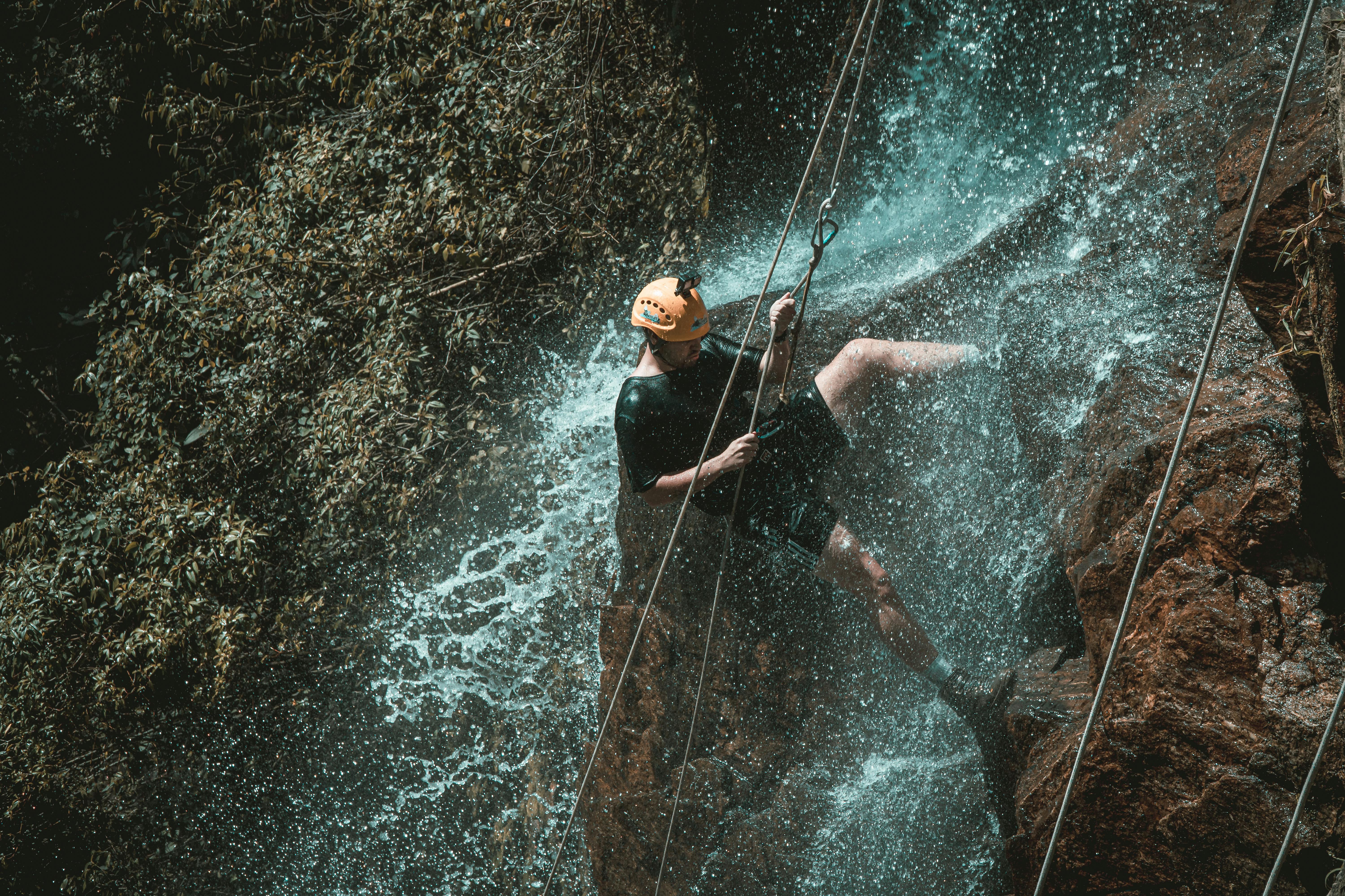 Active Man Rappelling on Cliff