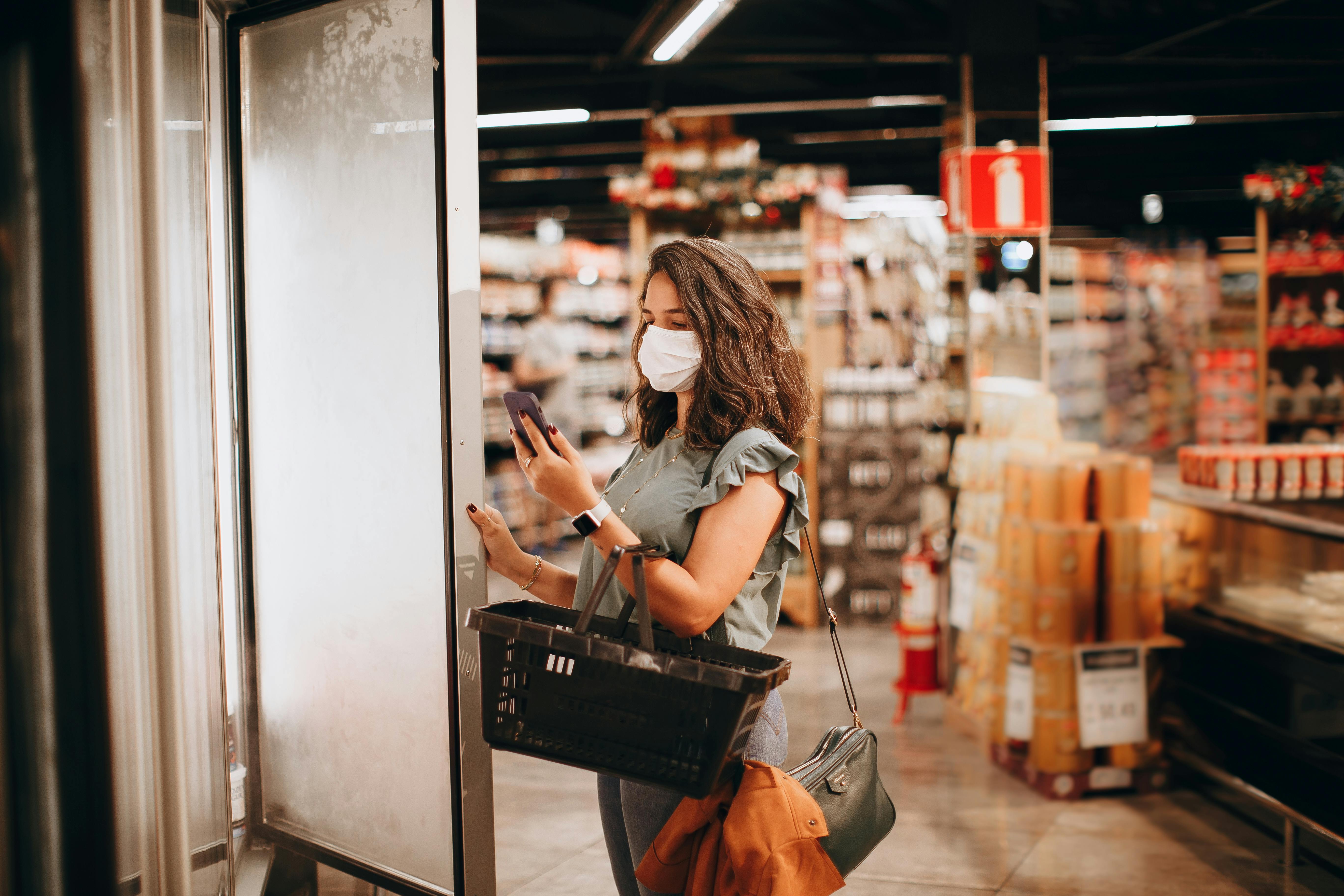 Woman Looking at a Shopping List in a Supermarket