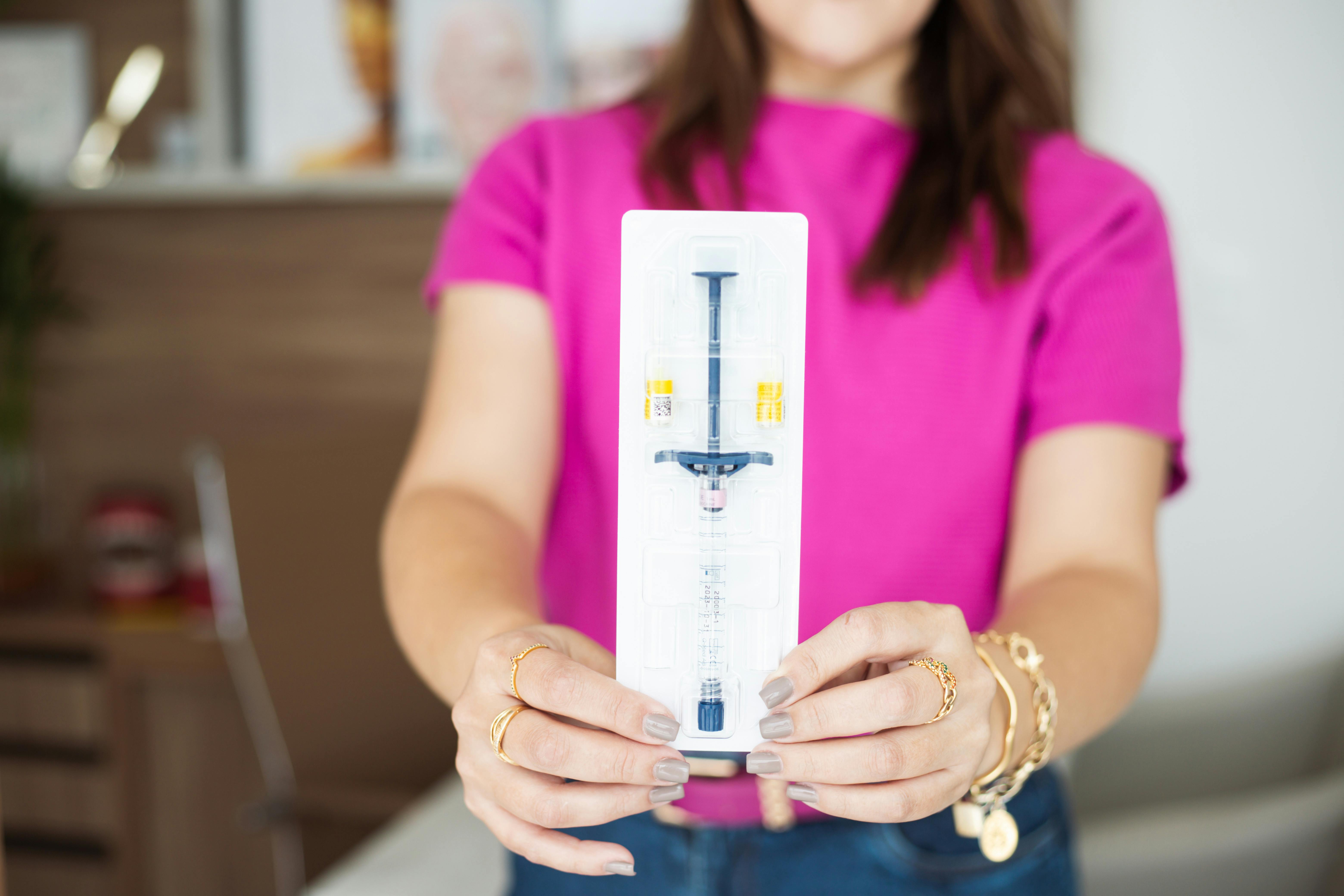 A woman holding up a box of a toothbrush