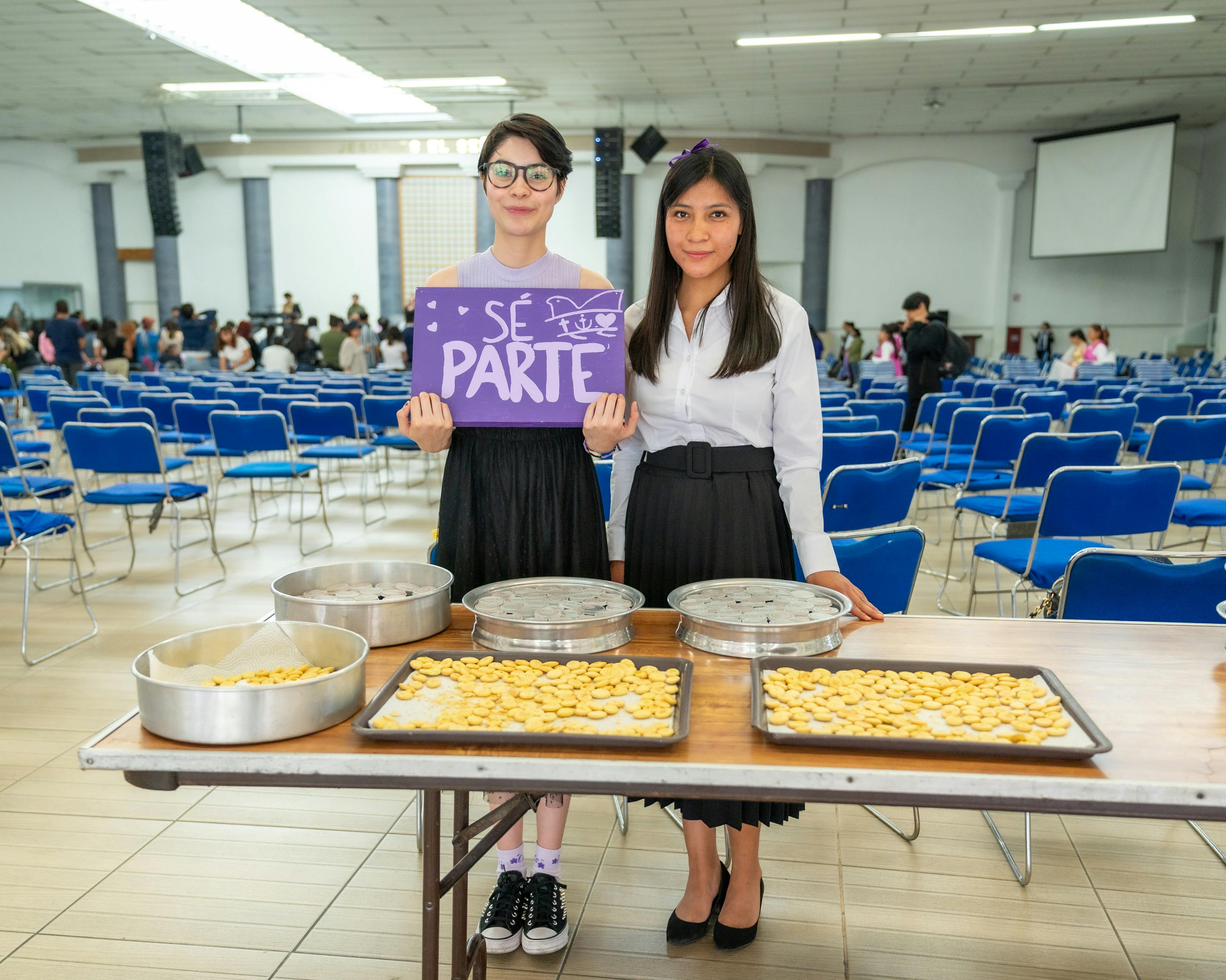 Two women standing in front of a table with food