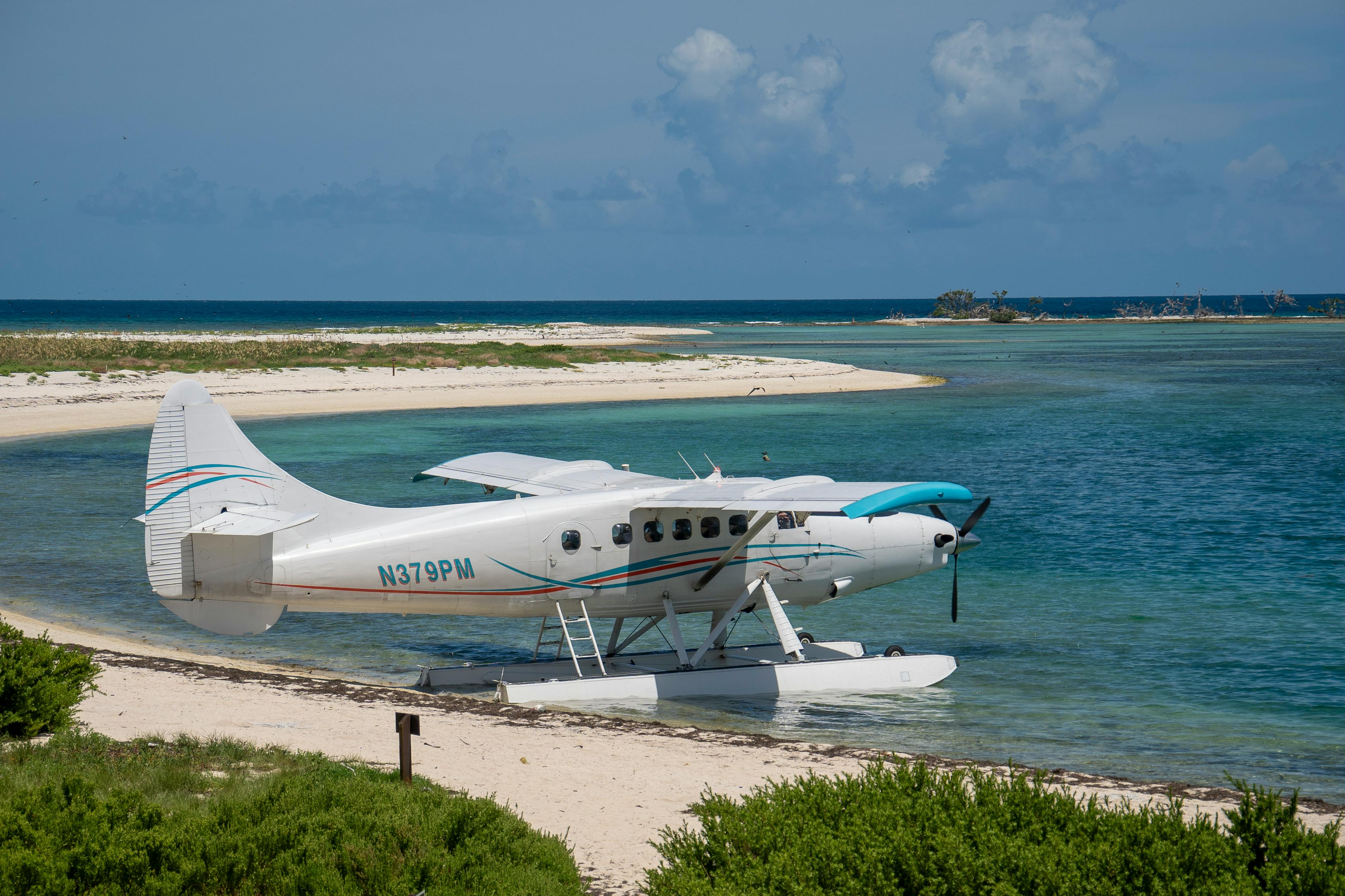 A small plane sitting on the beach near the water