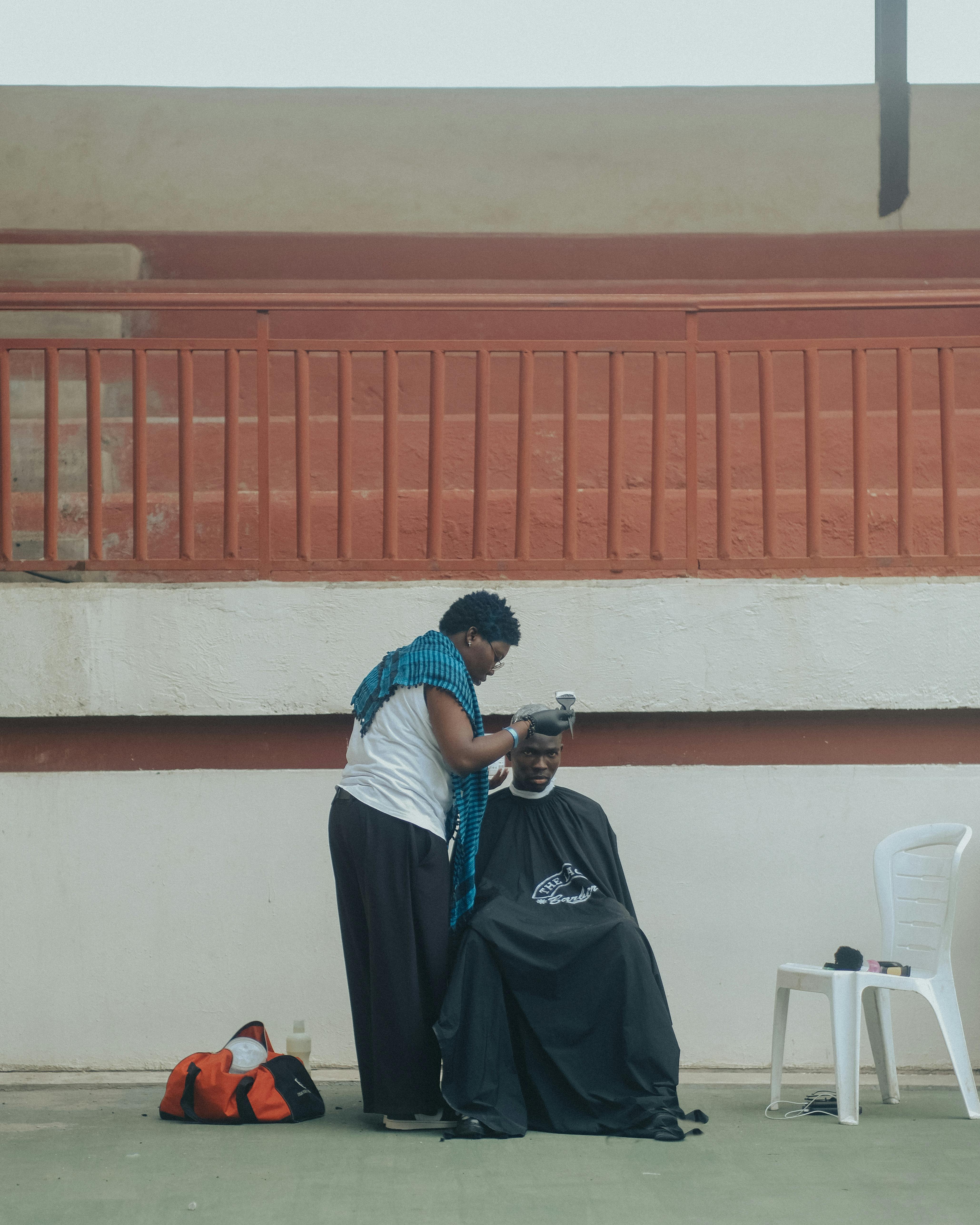 A woman is getting her hair cut by a man