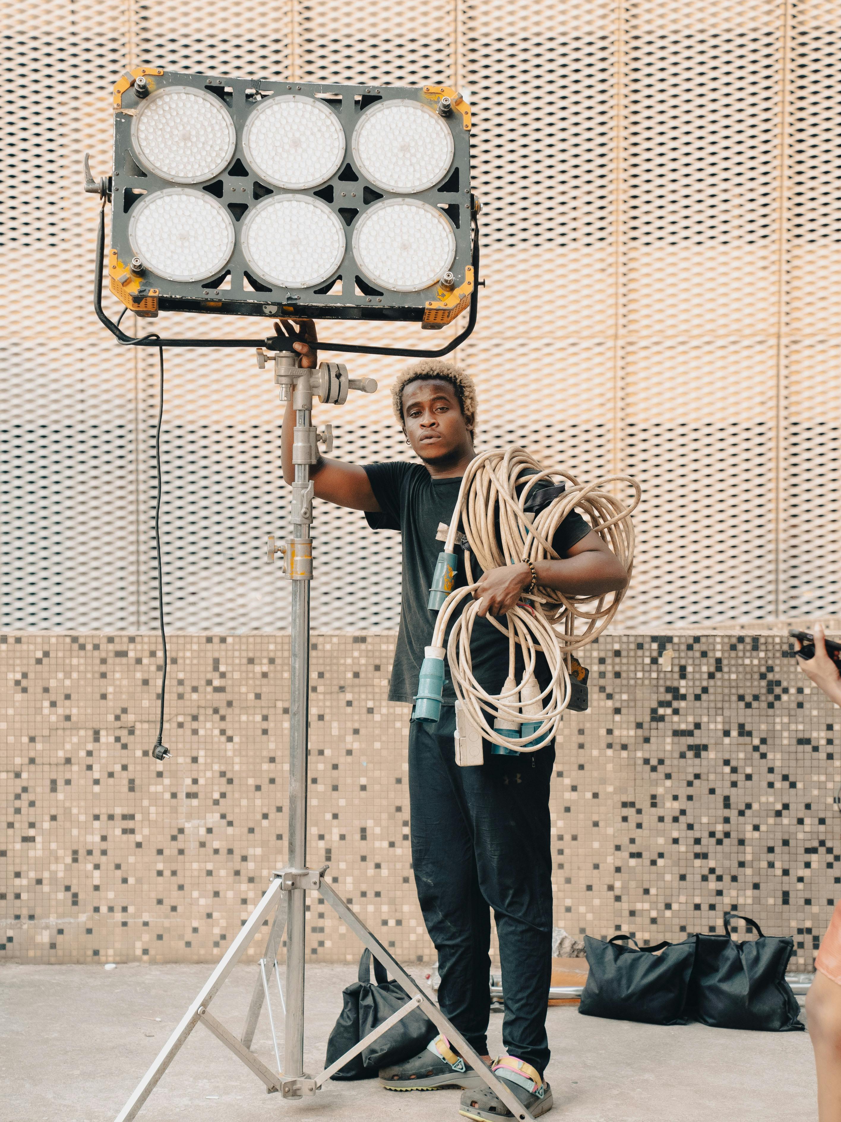 A man holding a light stand with a camera