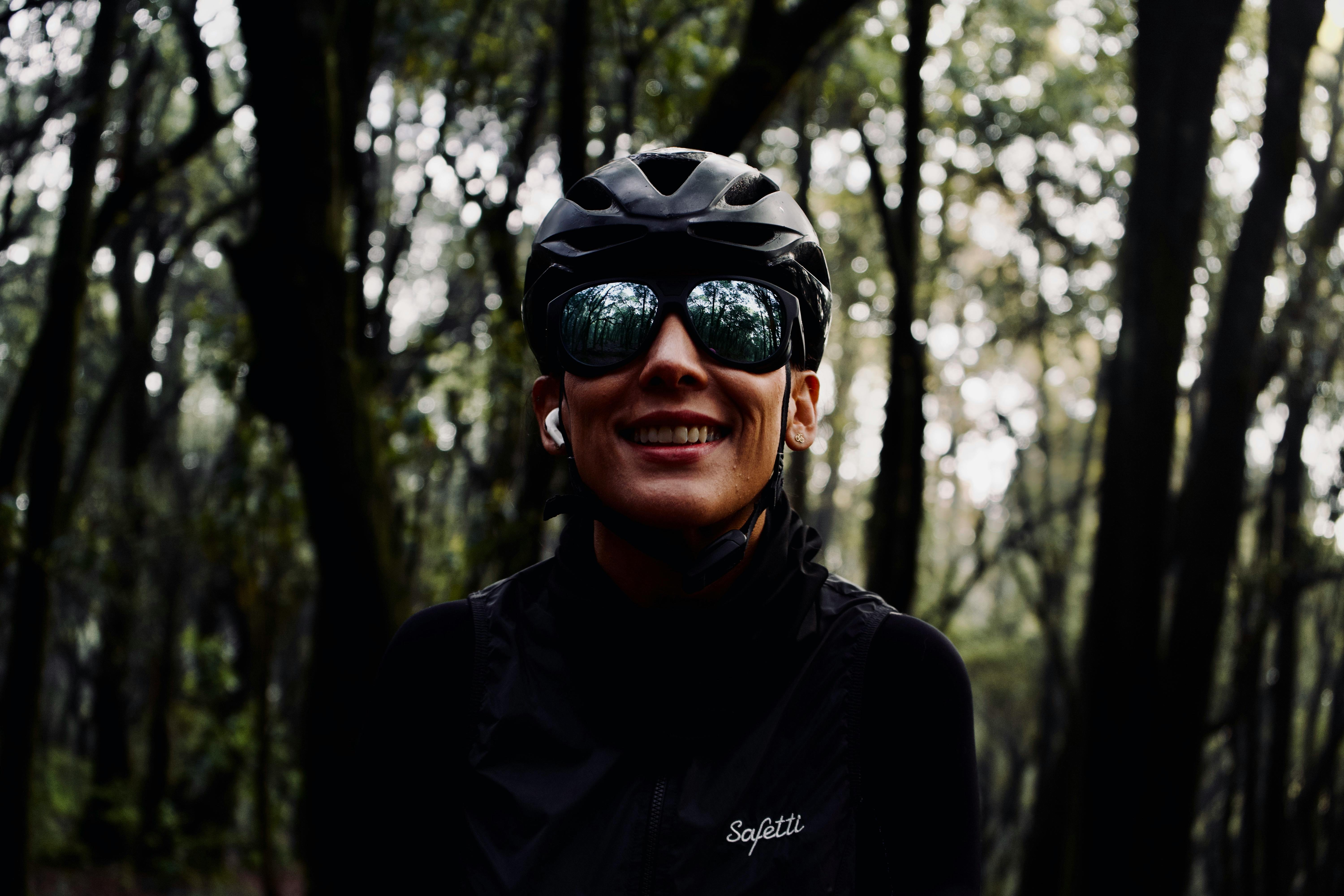 Cyclist Smiling in Forest with Helmet and Sunglasses
