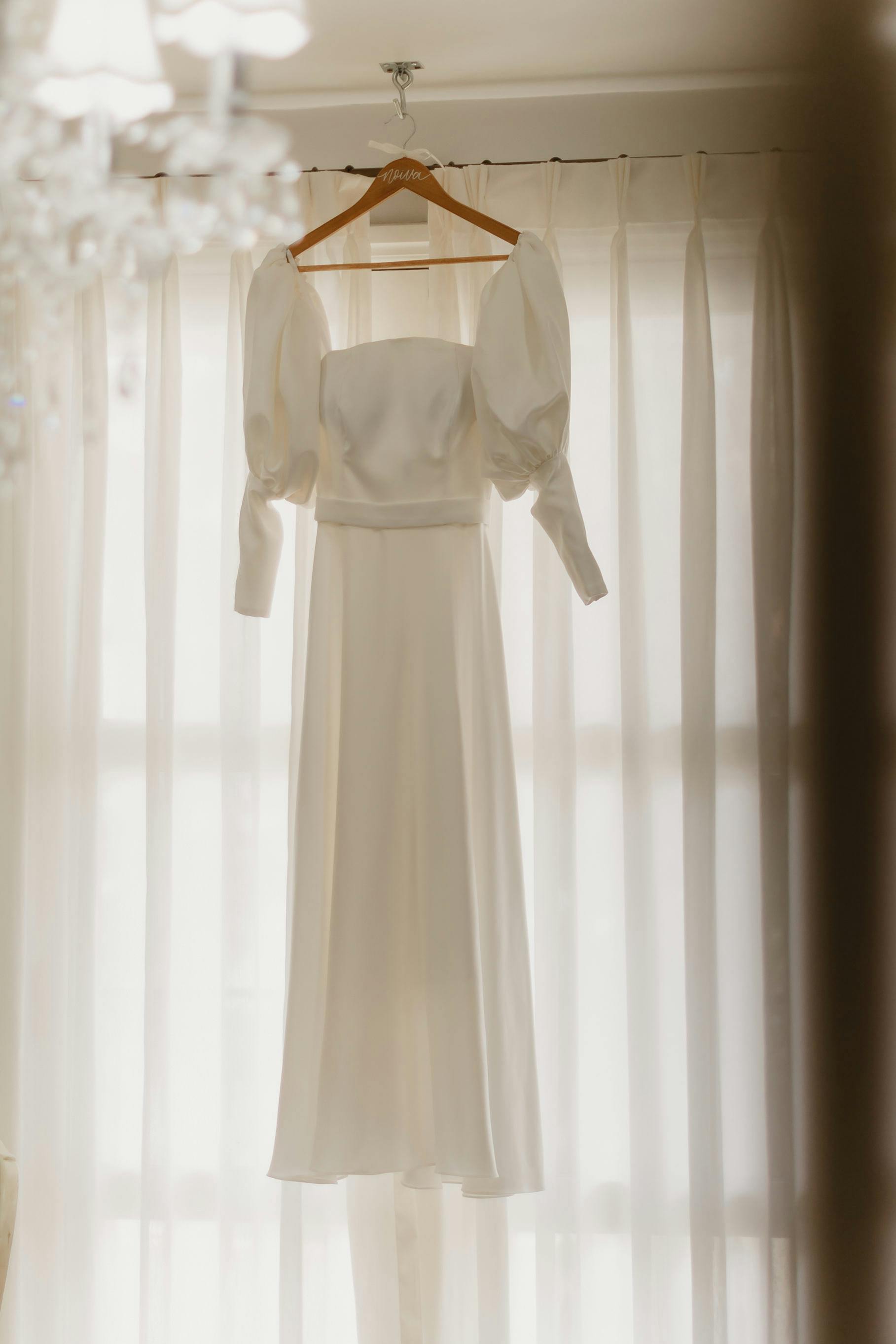 Elegant Bridal Gown on Hanger in Bright Room