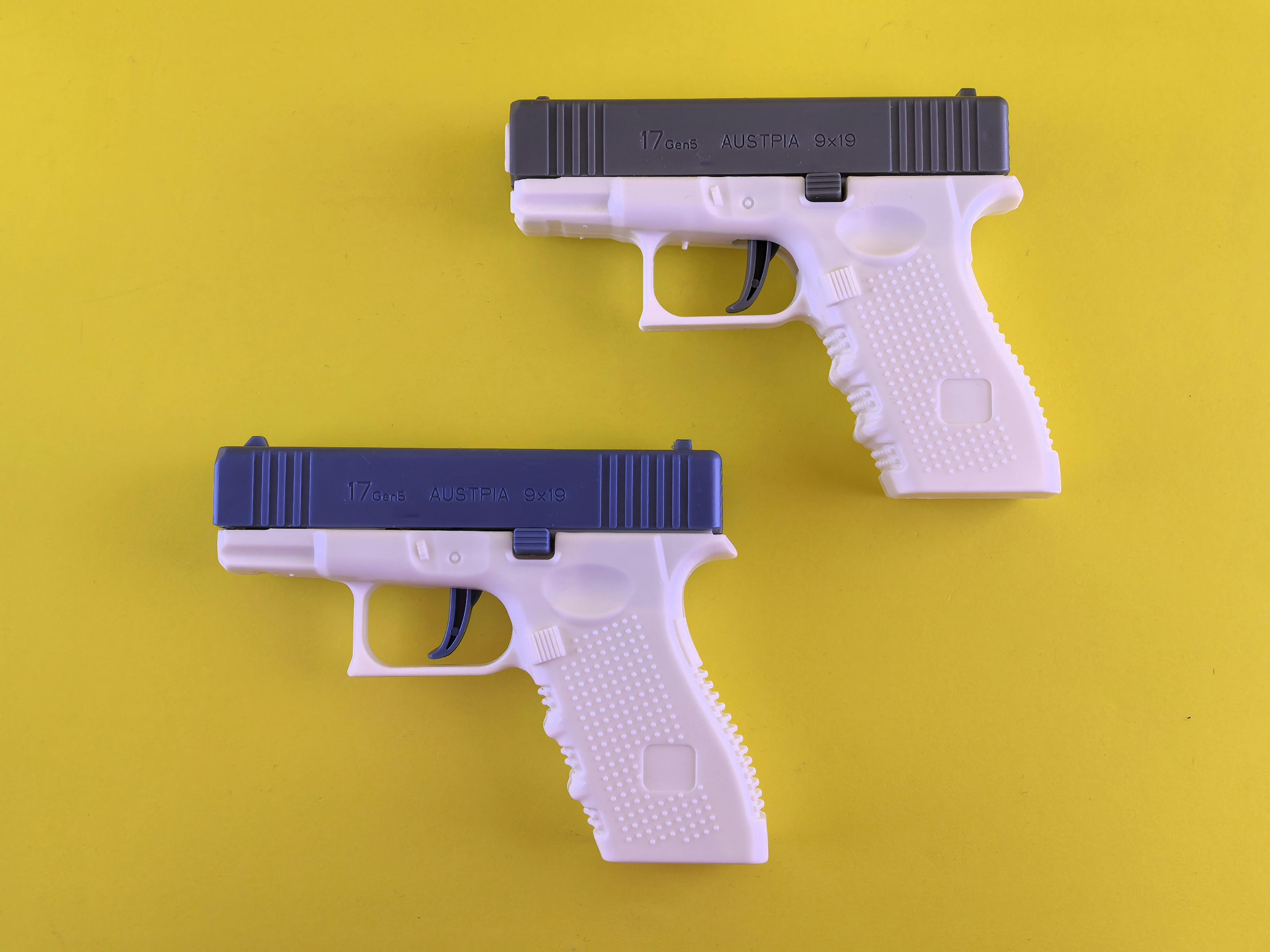 Plastic Toy Pistols on Vibrant Yellow Background