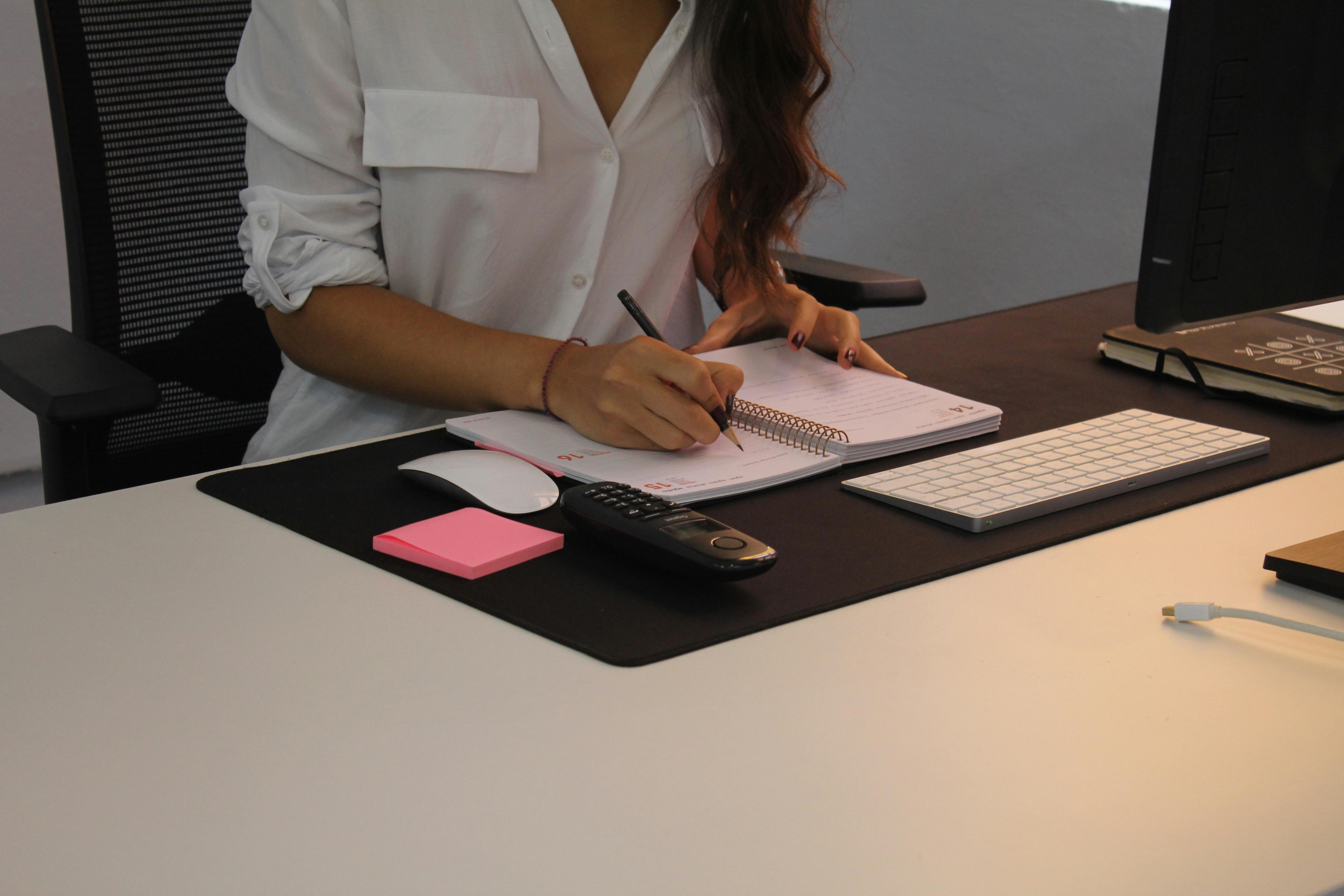 Professional Woman Working at Office Desk with Notebook