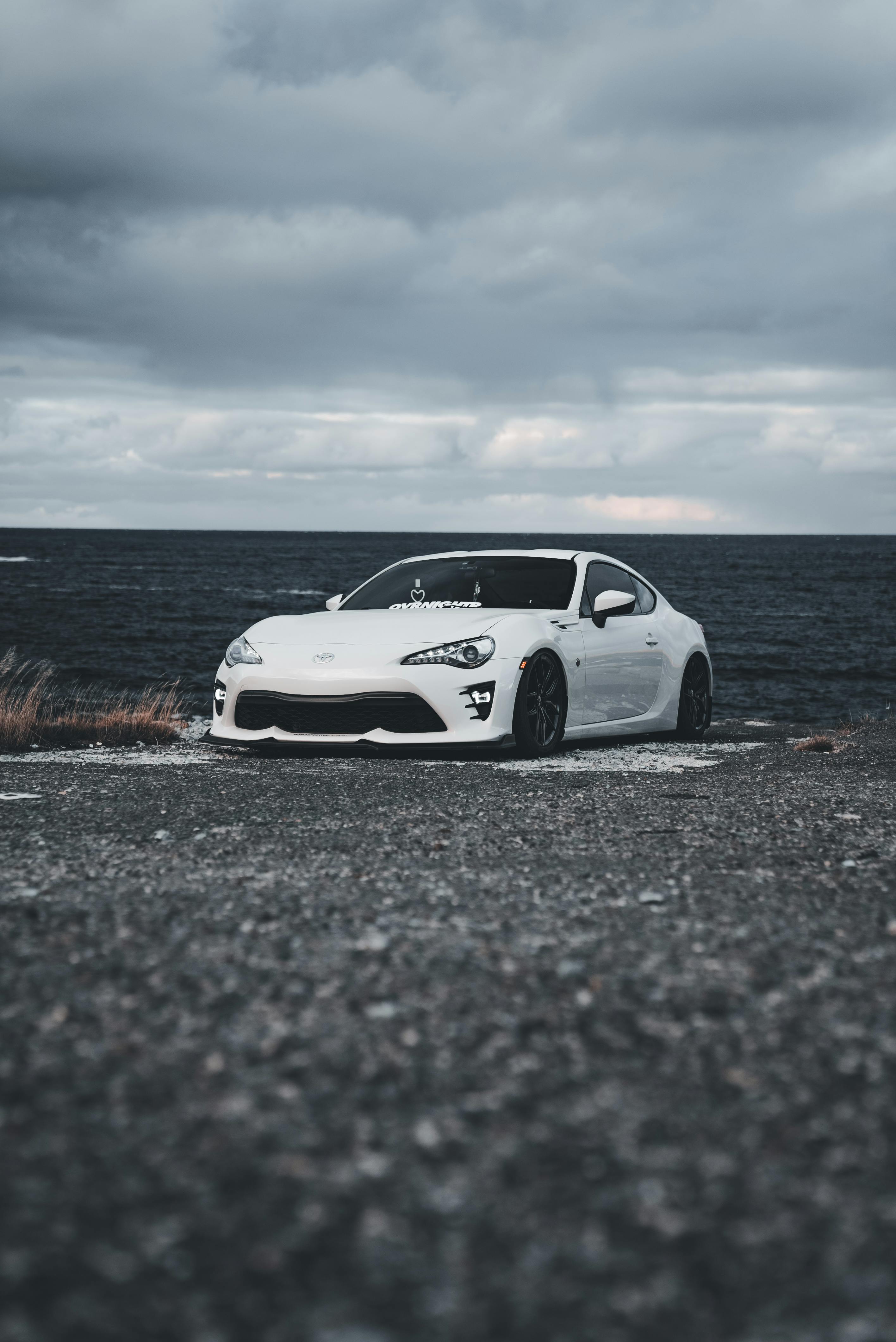 White sports car parked by the ocean