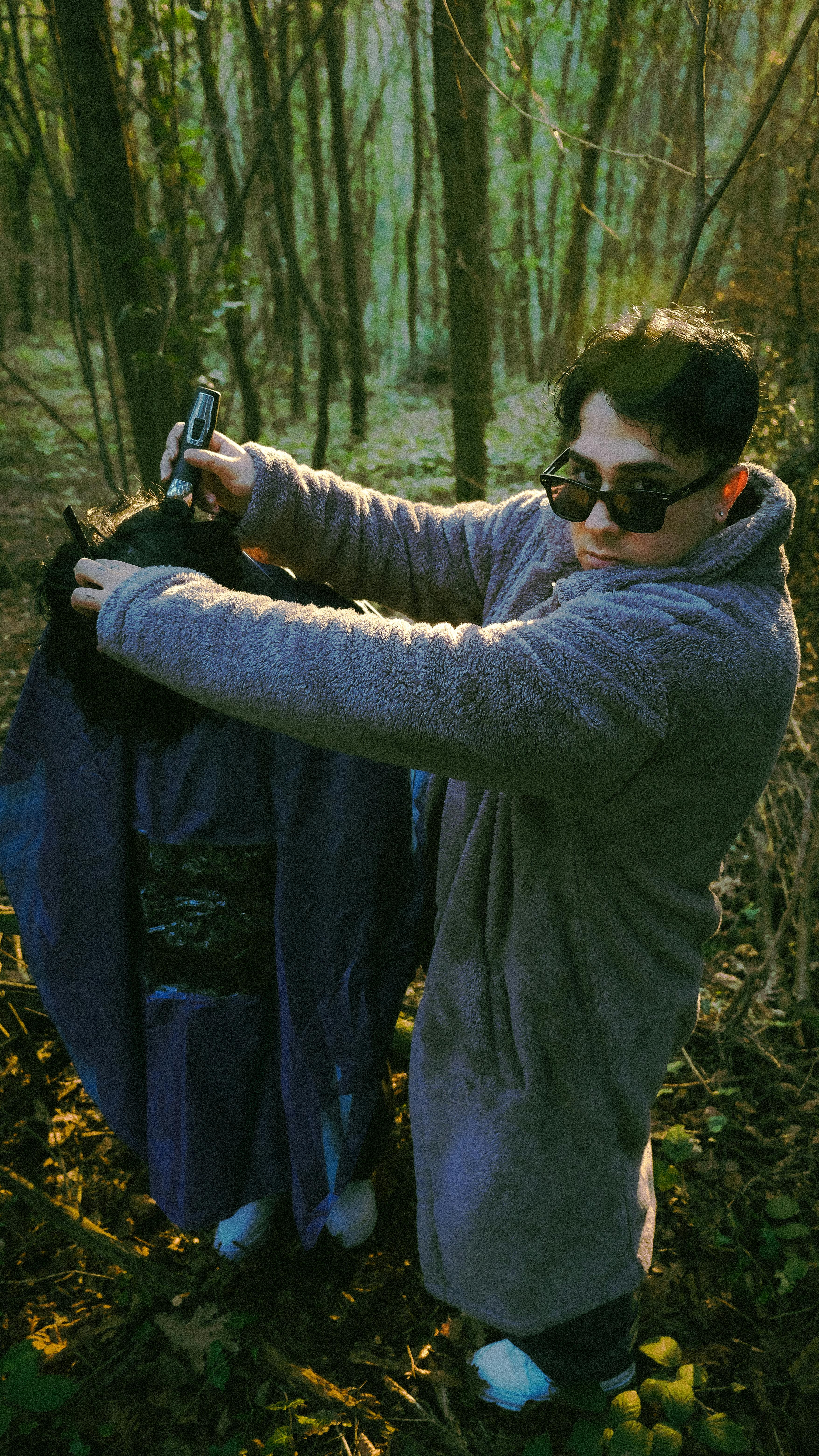 Young Man in Forest with Garbage Bag