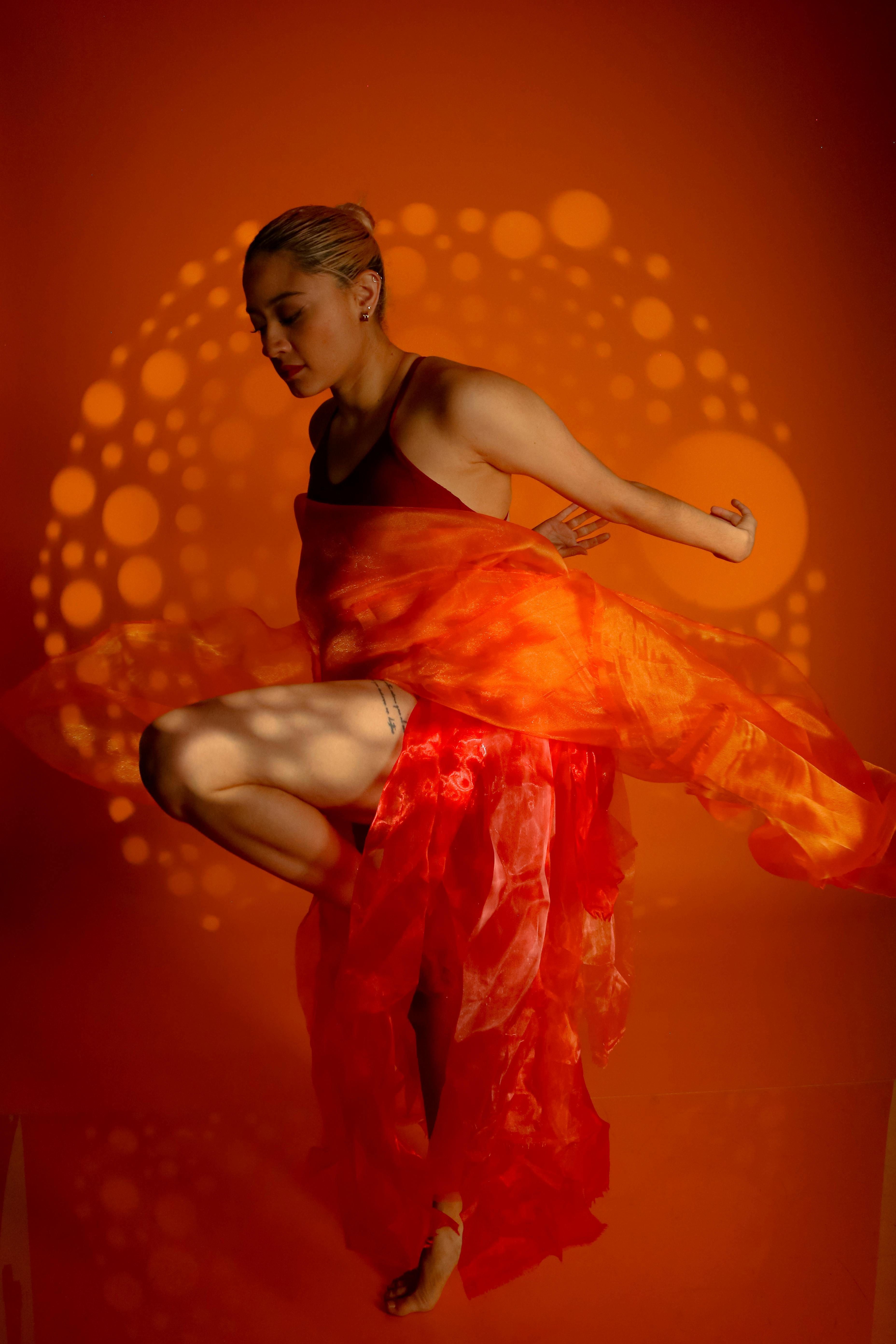 Dynamic Artistic Dance Leap in Vibrant Orange