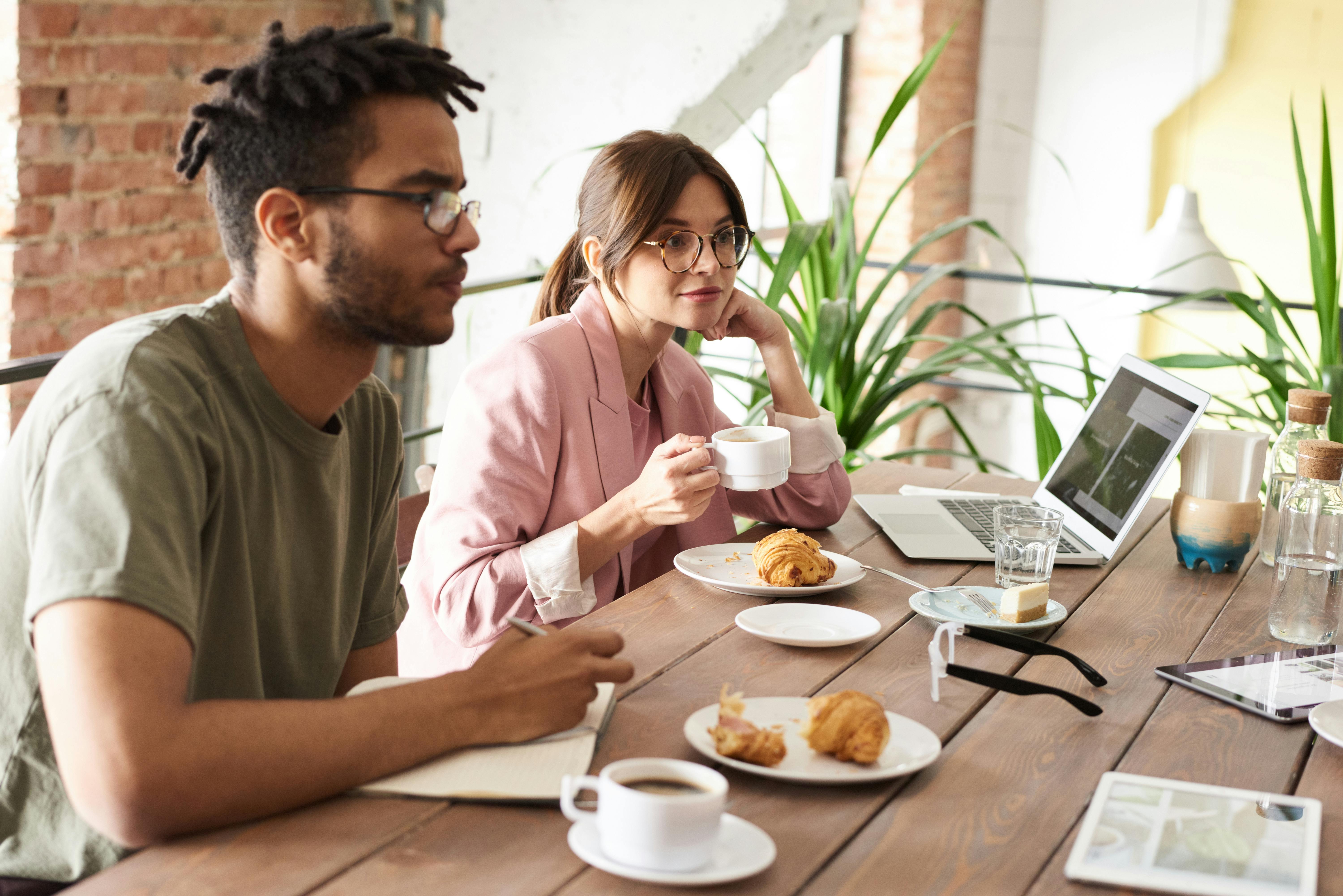 Photo Of People Sitting Near Wooden Table