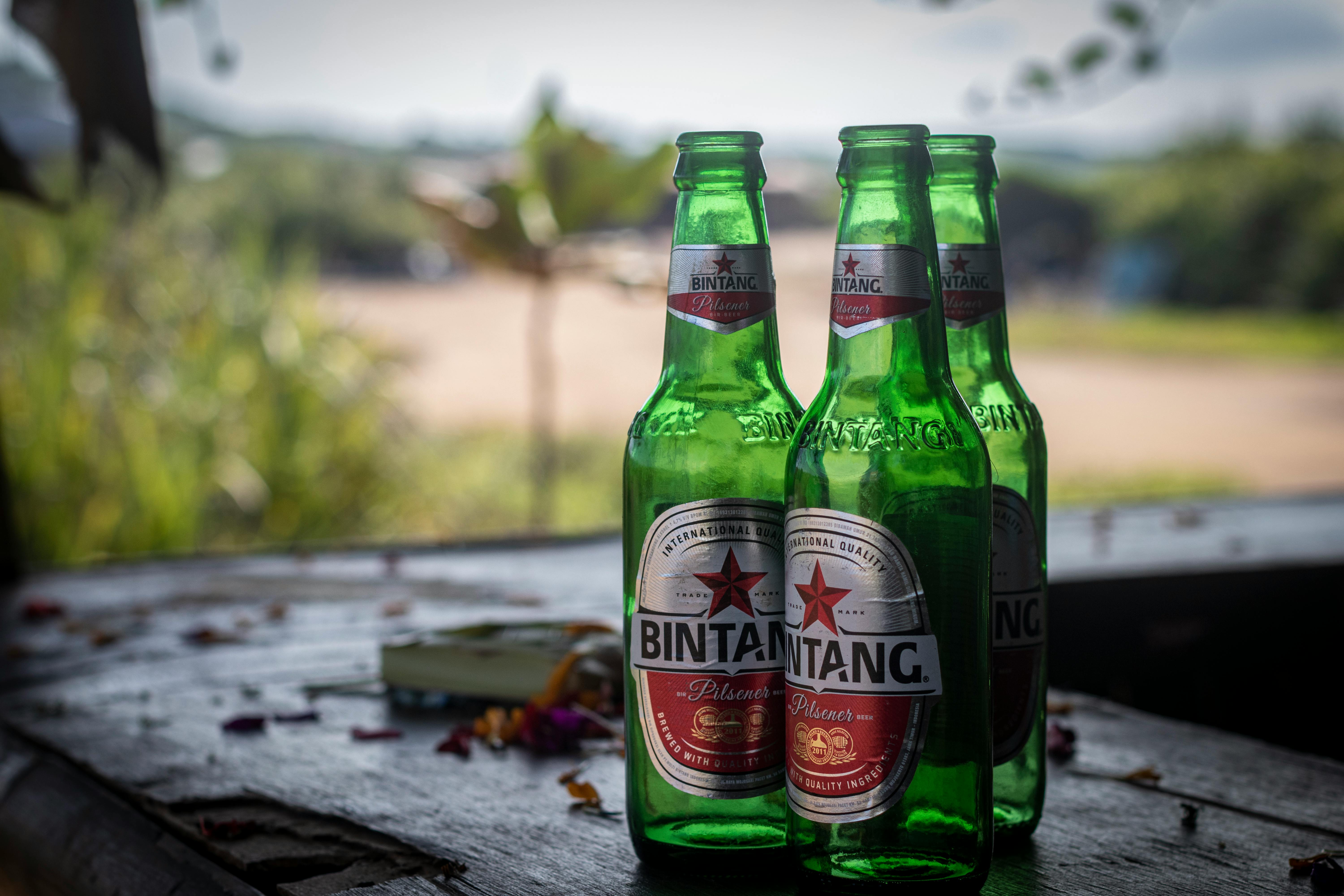 Green Glass Bottles on Wooden Surface