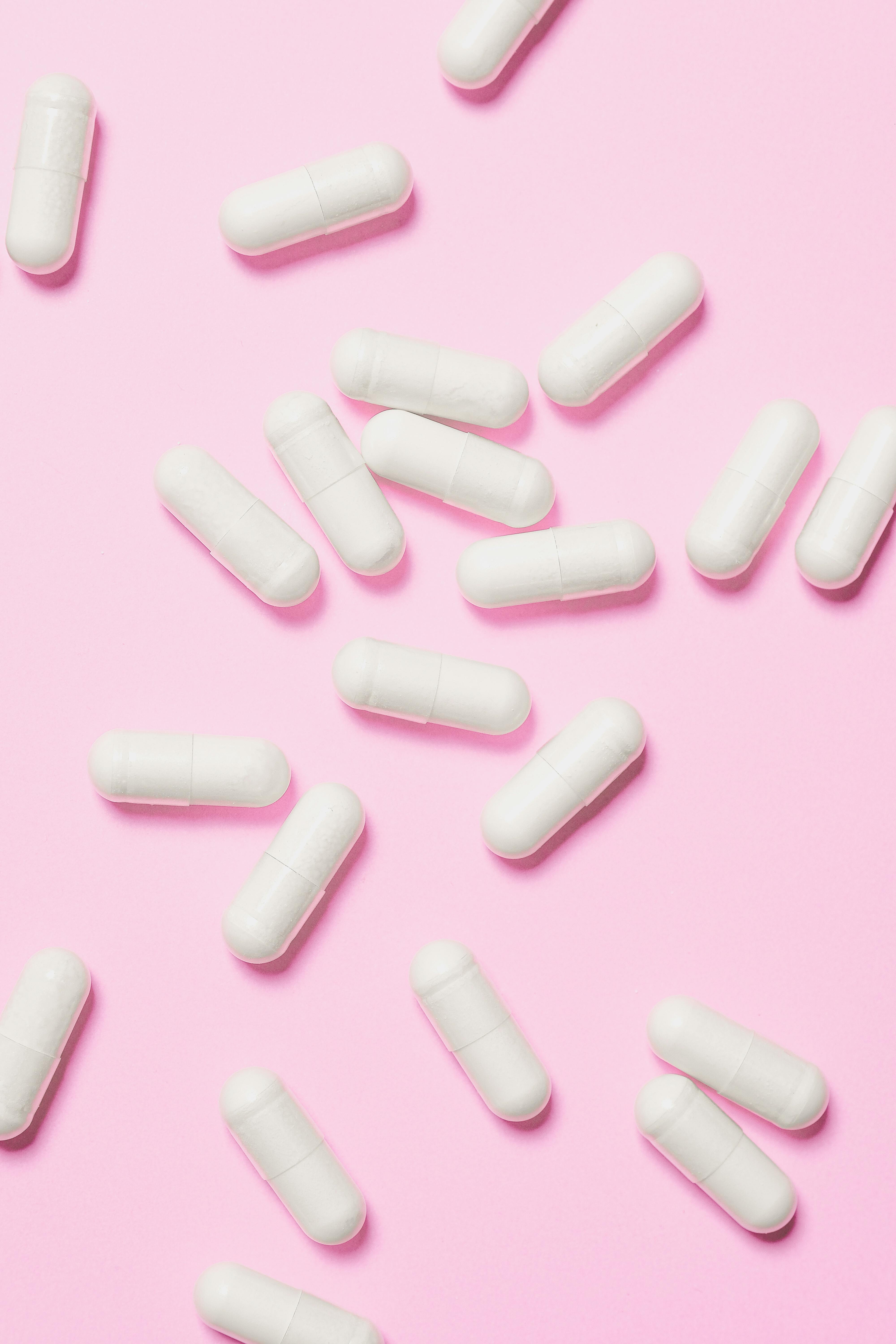 White Capsules on Pink Surface