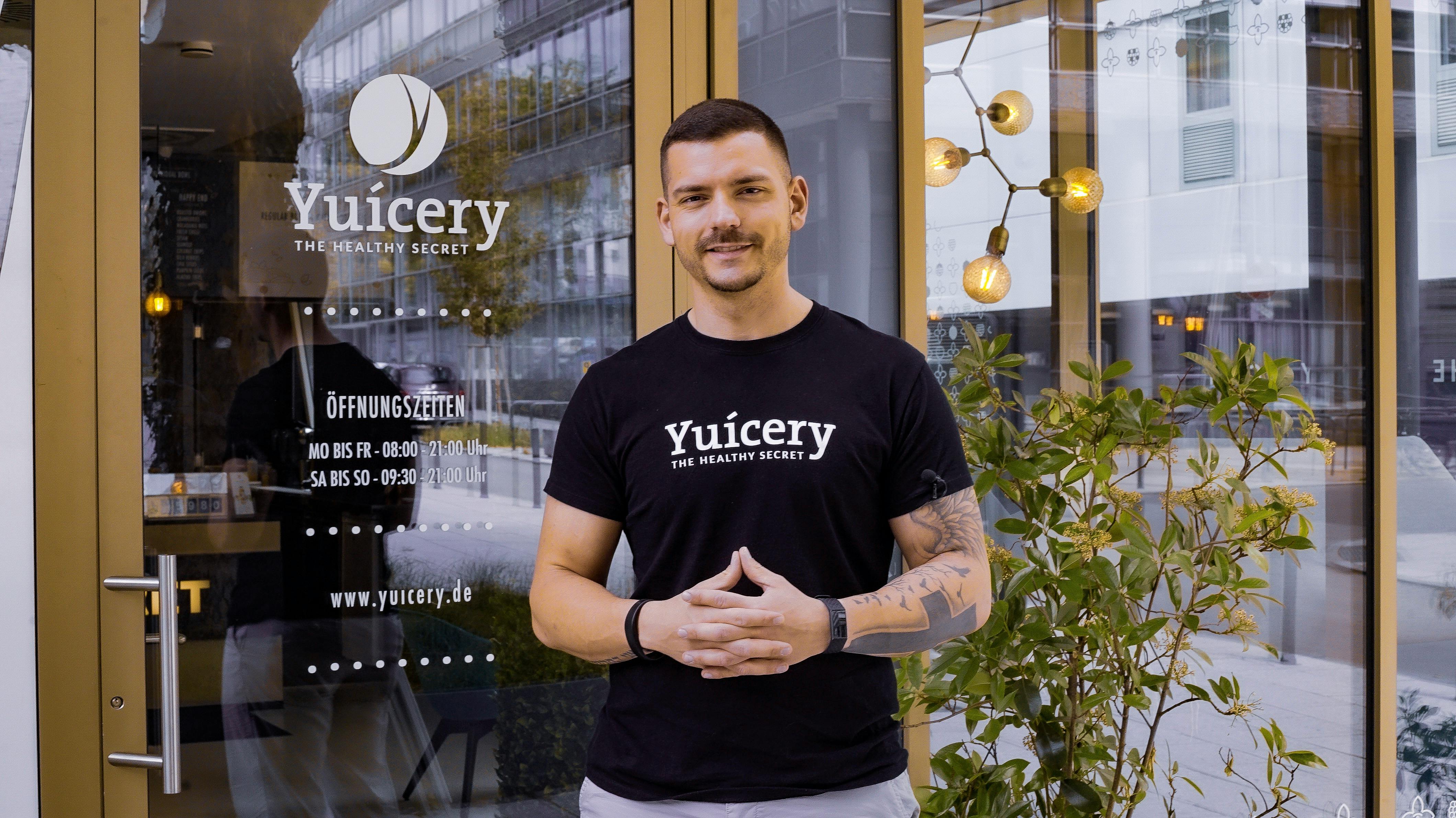 Man in Black Crew Neck T-shirt Standing Beside Green Plant