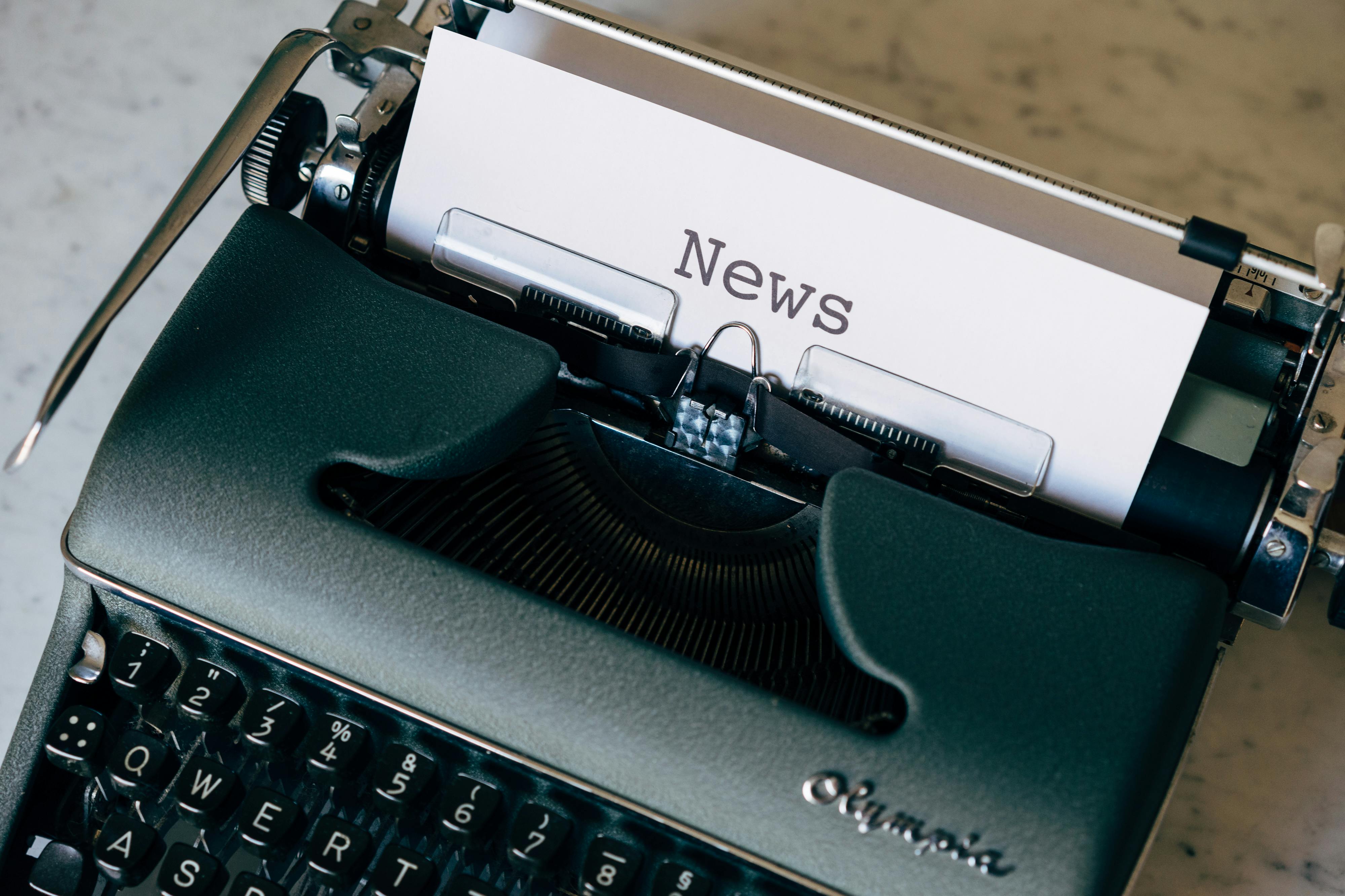 Green Typewriter With White Paper