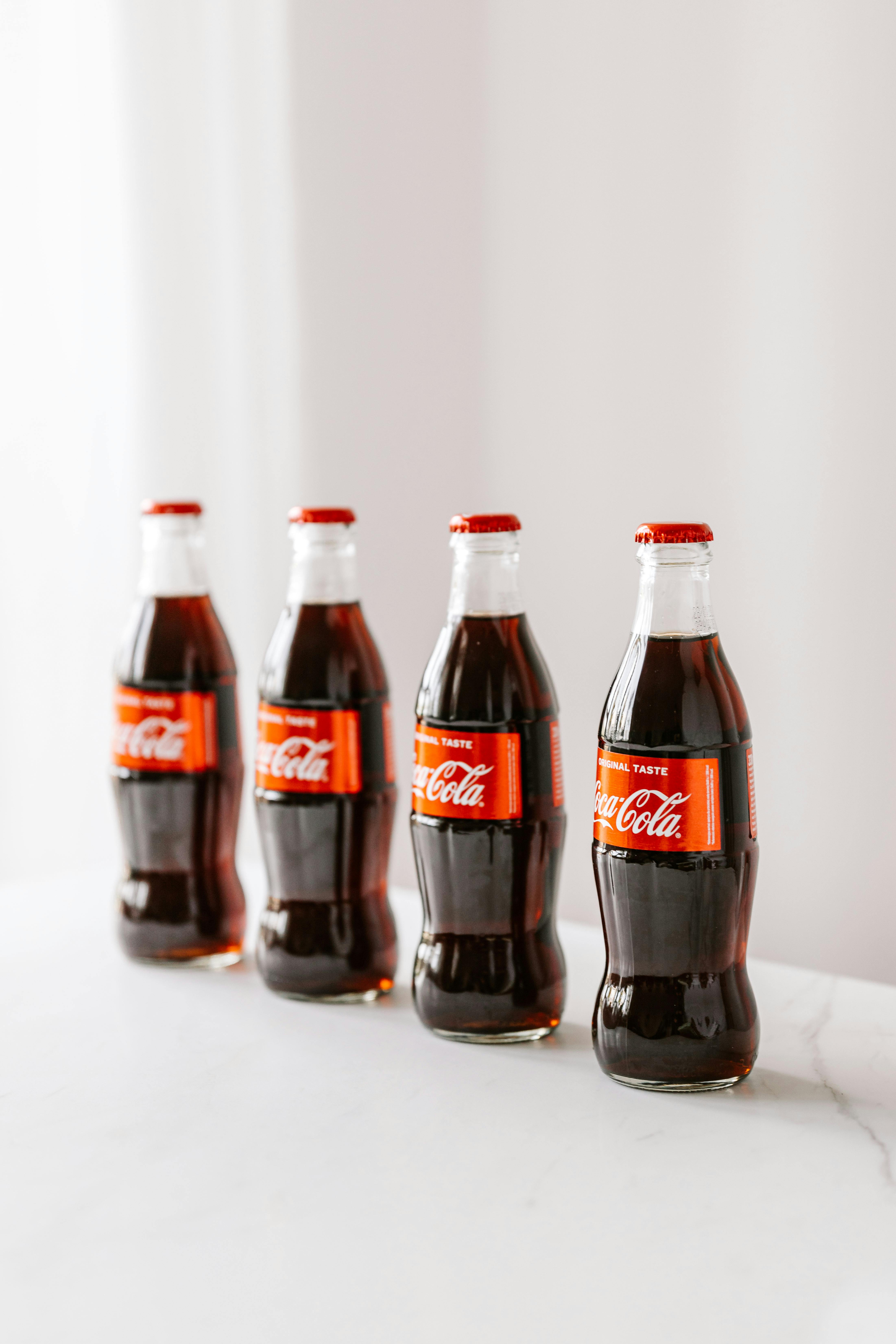 Bottles of coke placed on white surface