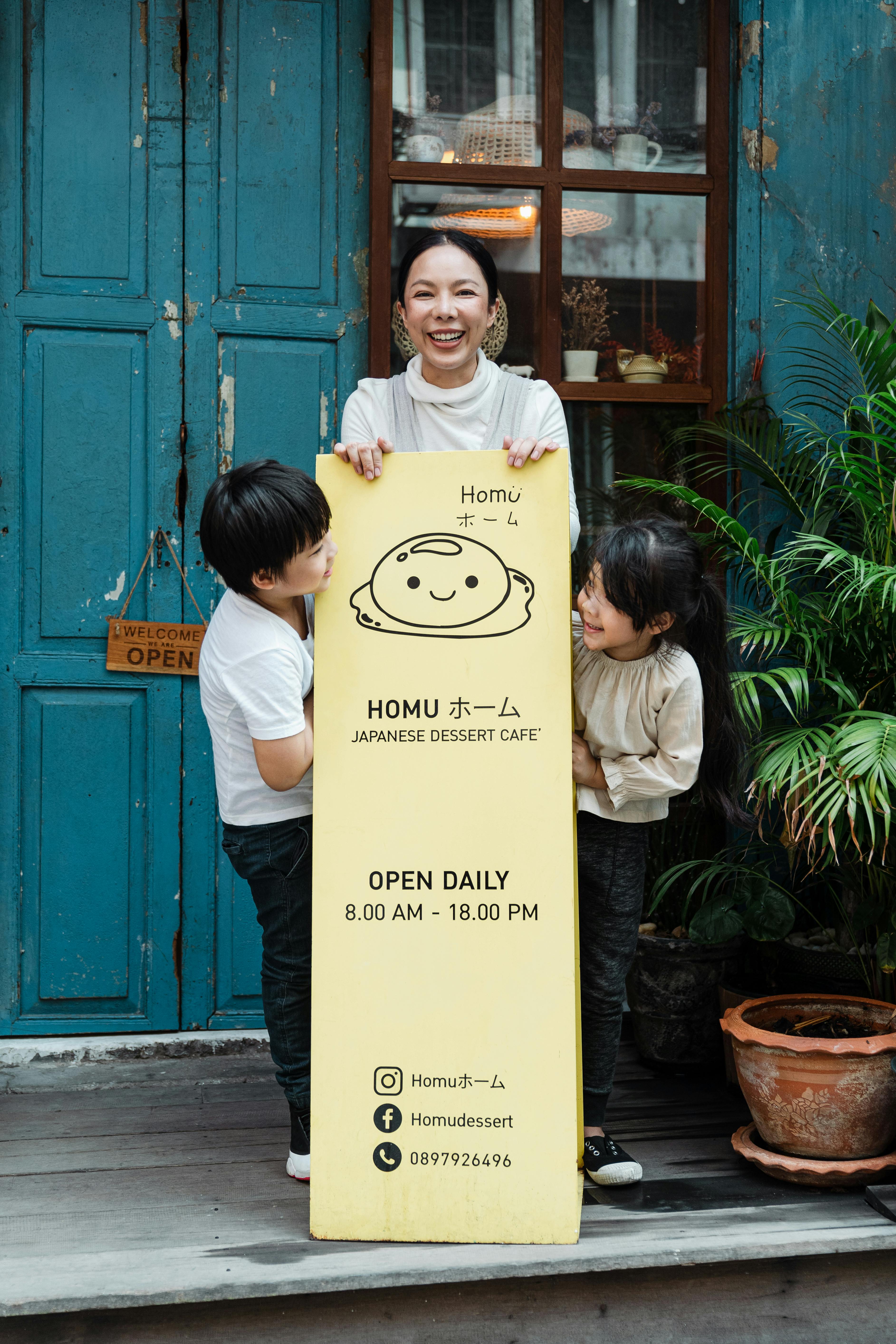 Photo of Family Smiling While Standing Near Signage