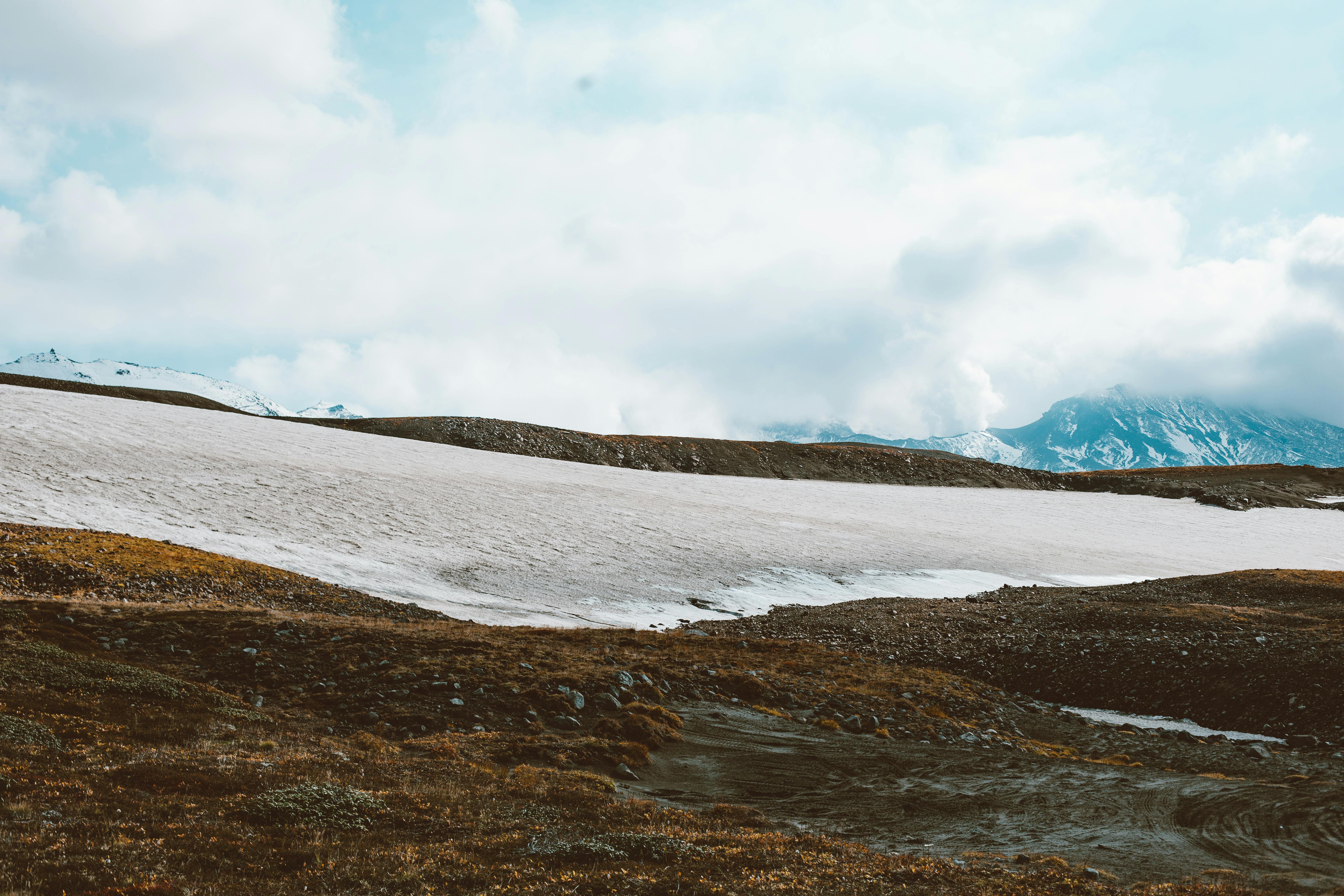 Picturesque view of distant mountain ridge hiding in dense clouds of volcano smog and desert terrain below