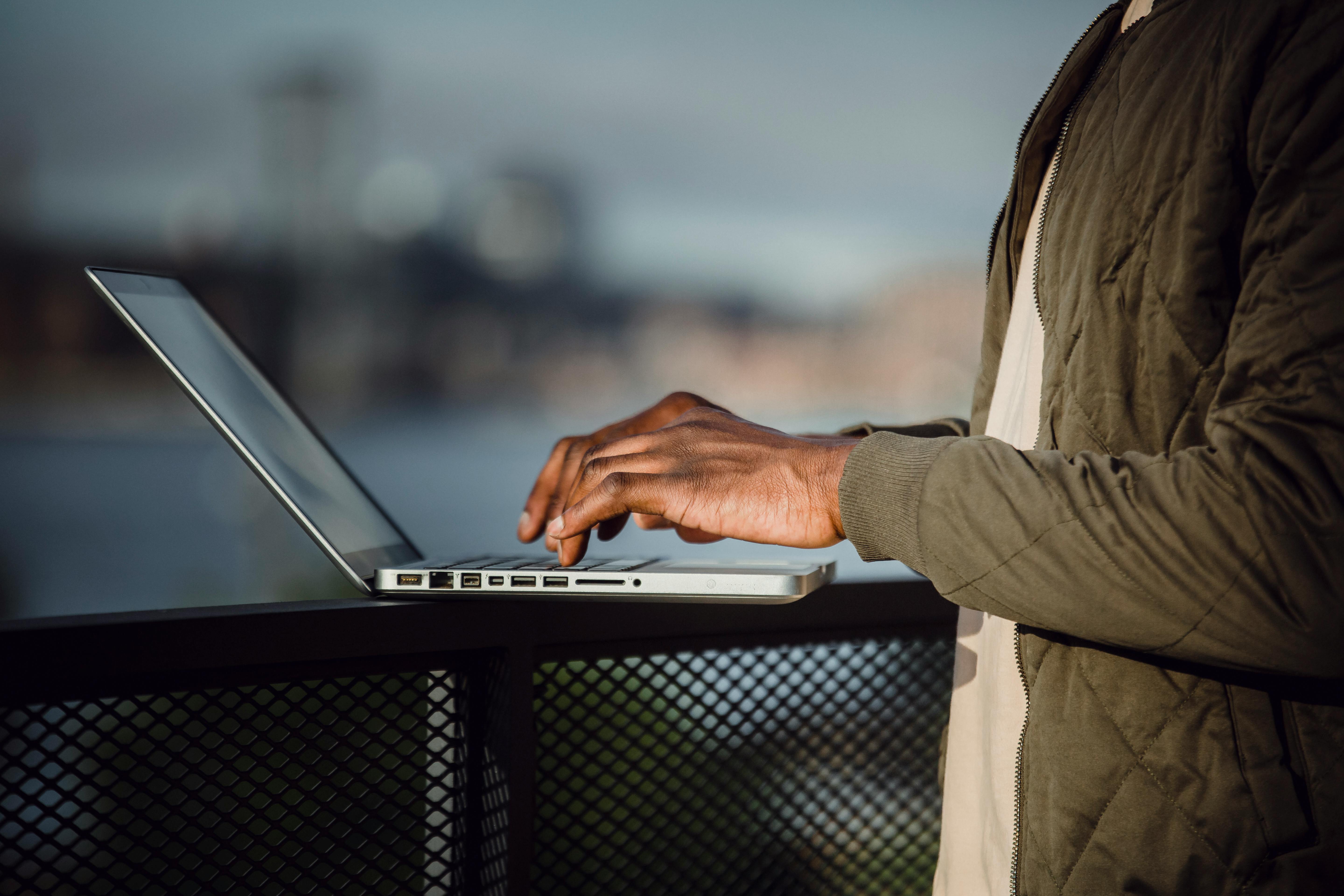 Crop man working on laptop on open terrace