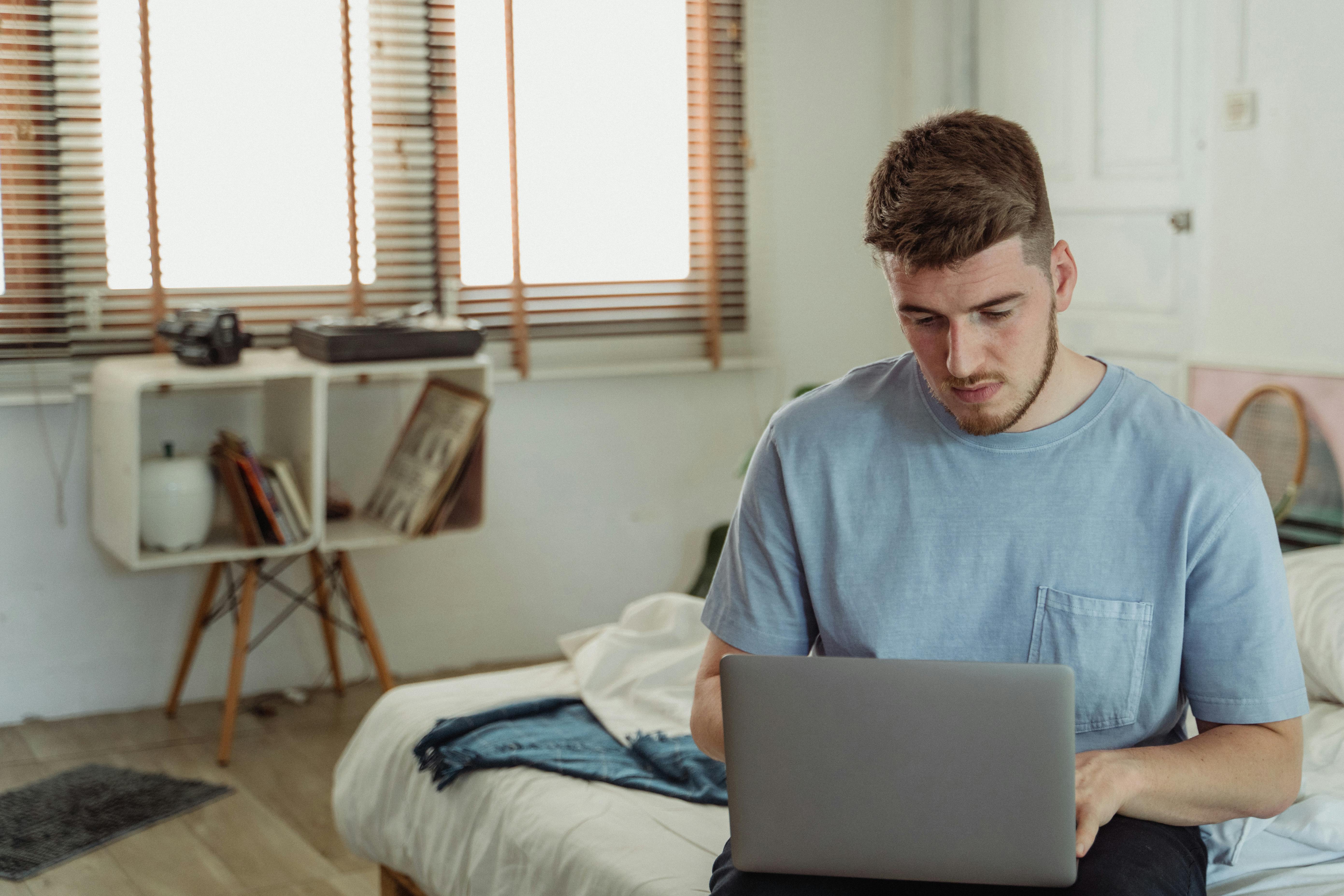 Man in Blue Crew Neck T-shirt Using Macbook Laptop