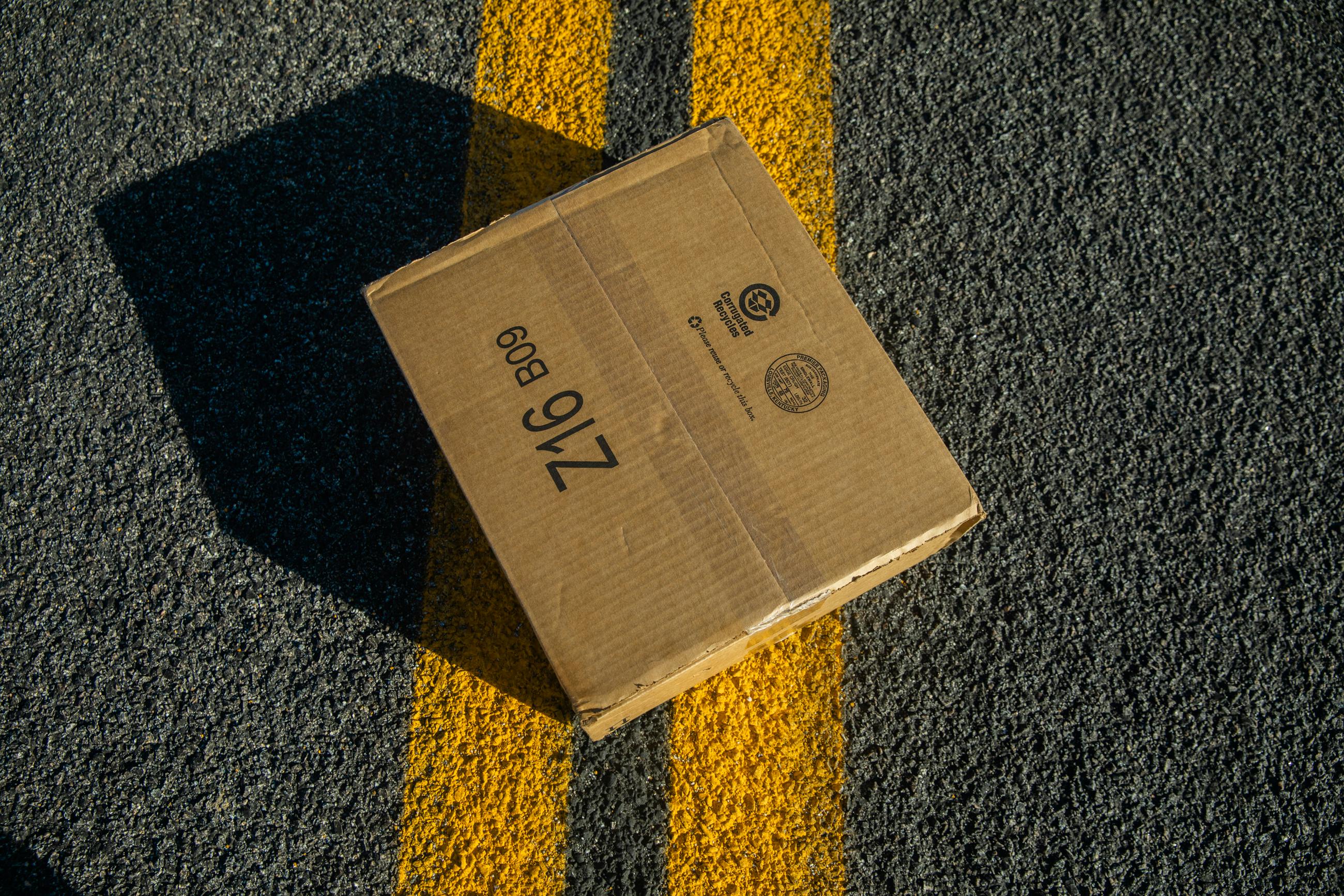 Carton Box on Yellow Lines on Road