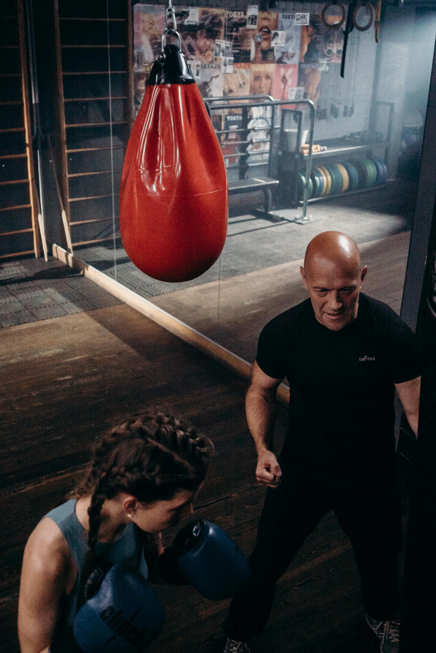 Man in Black Crew Neck T-shirt and Black Shorts Holding Red Boxing Gloves