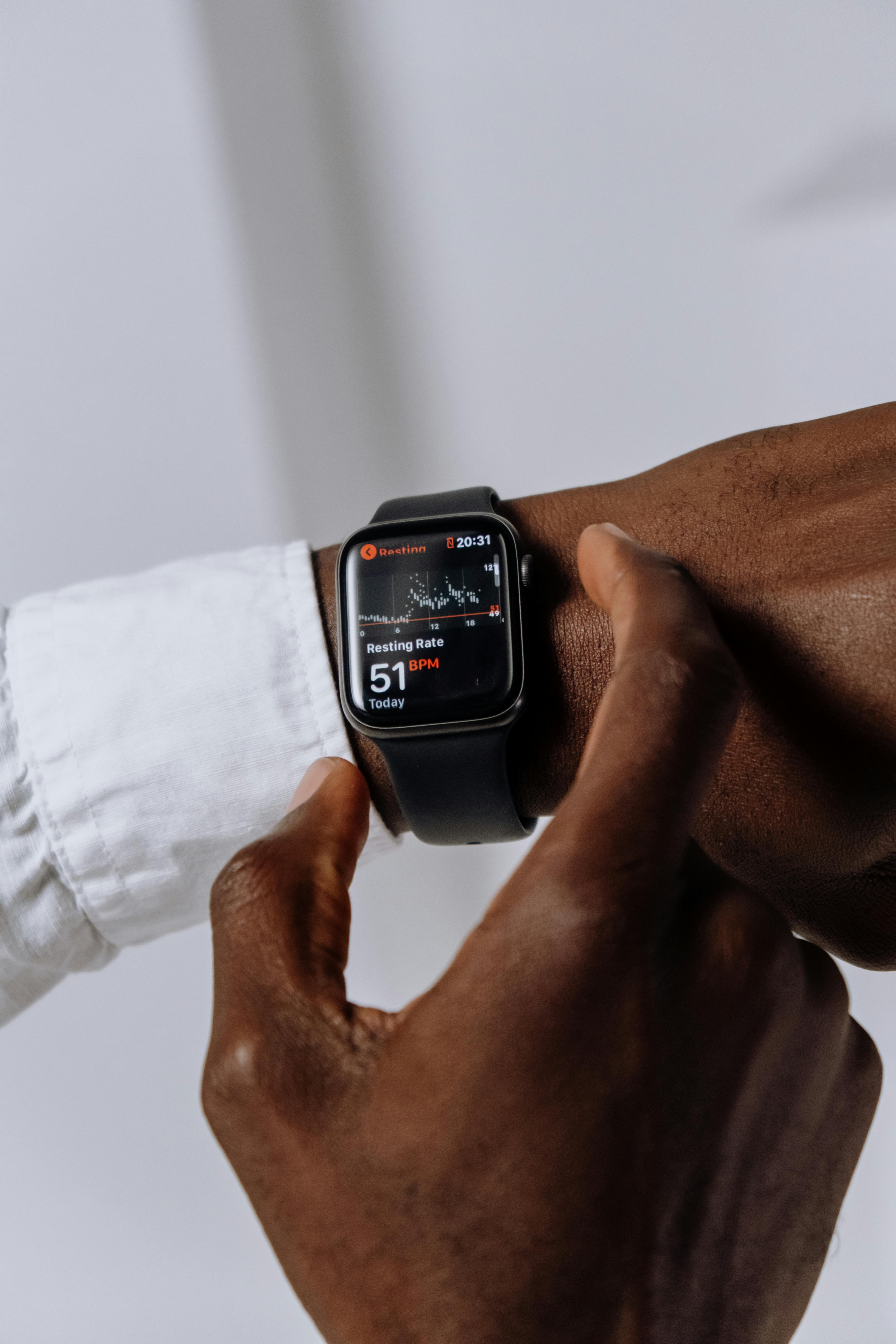 Person Wearing Silver Aluminum Case Apple Watch With White Sport Band