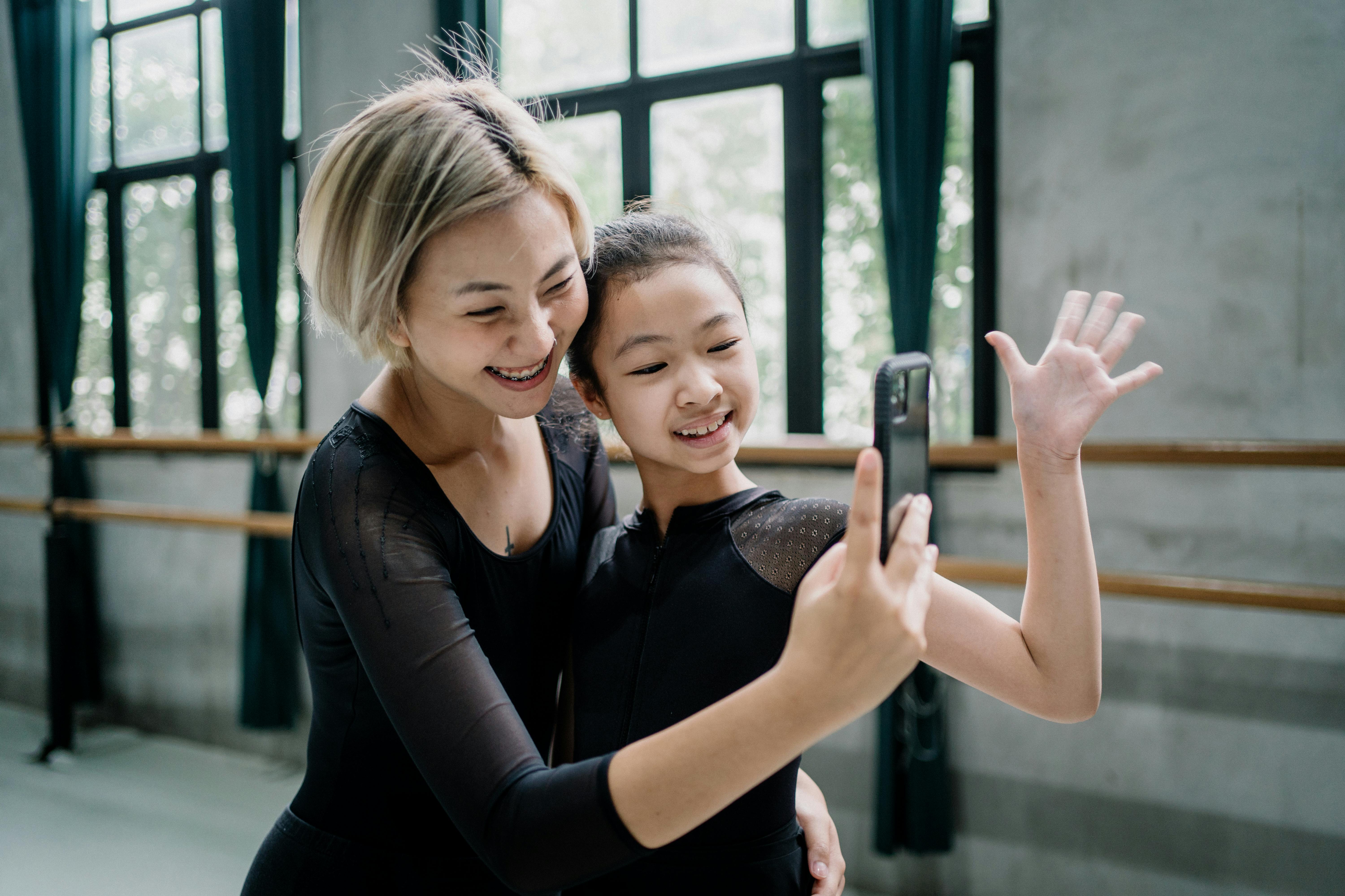 Delighted female ballet instructor and girl trainee taking a selfie