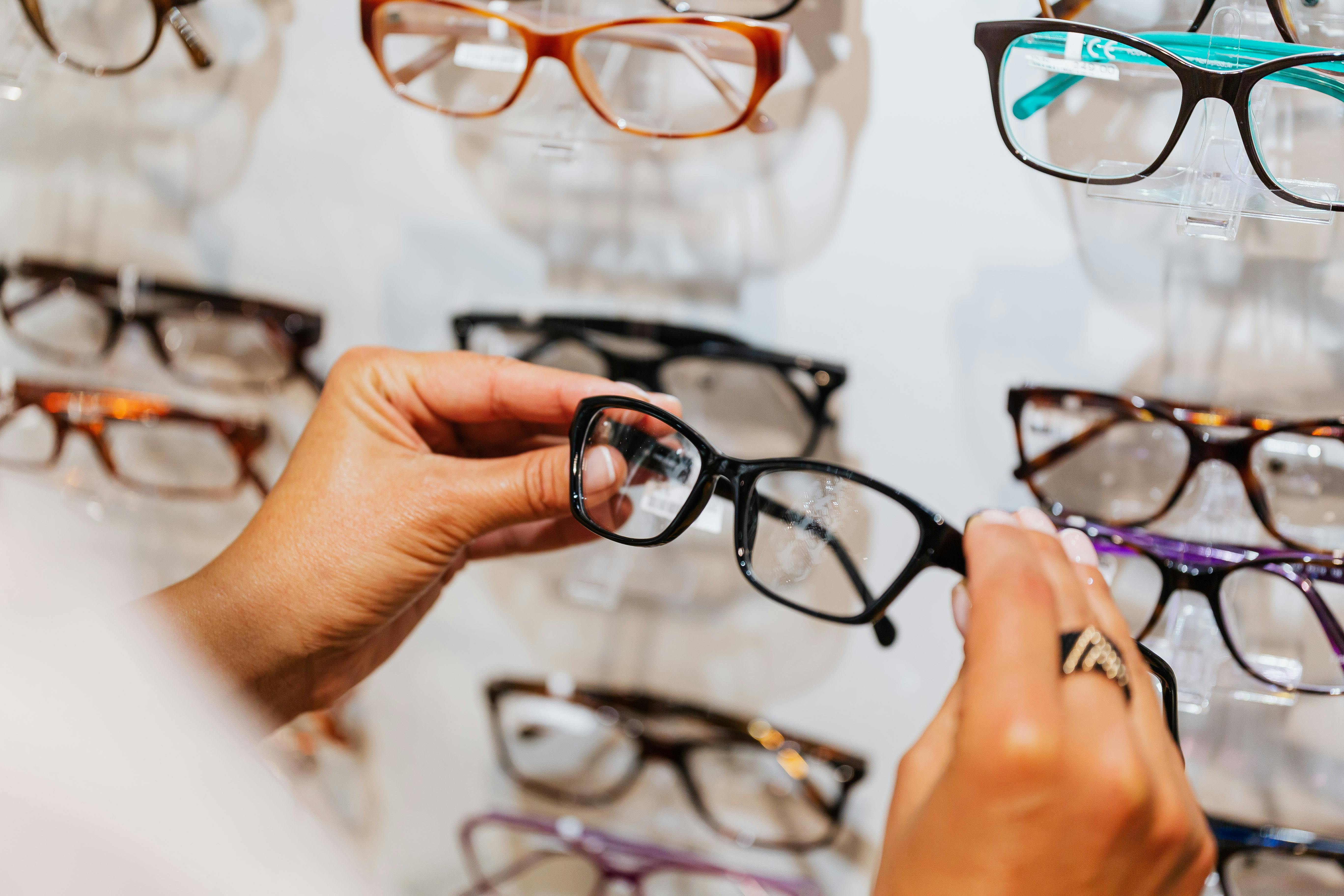 Person Holding Black Framed Eyeglasses