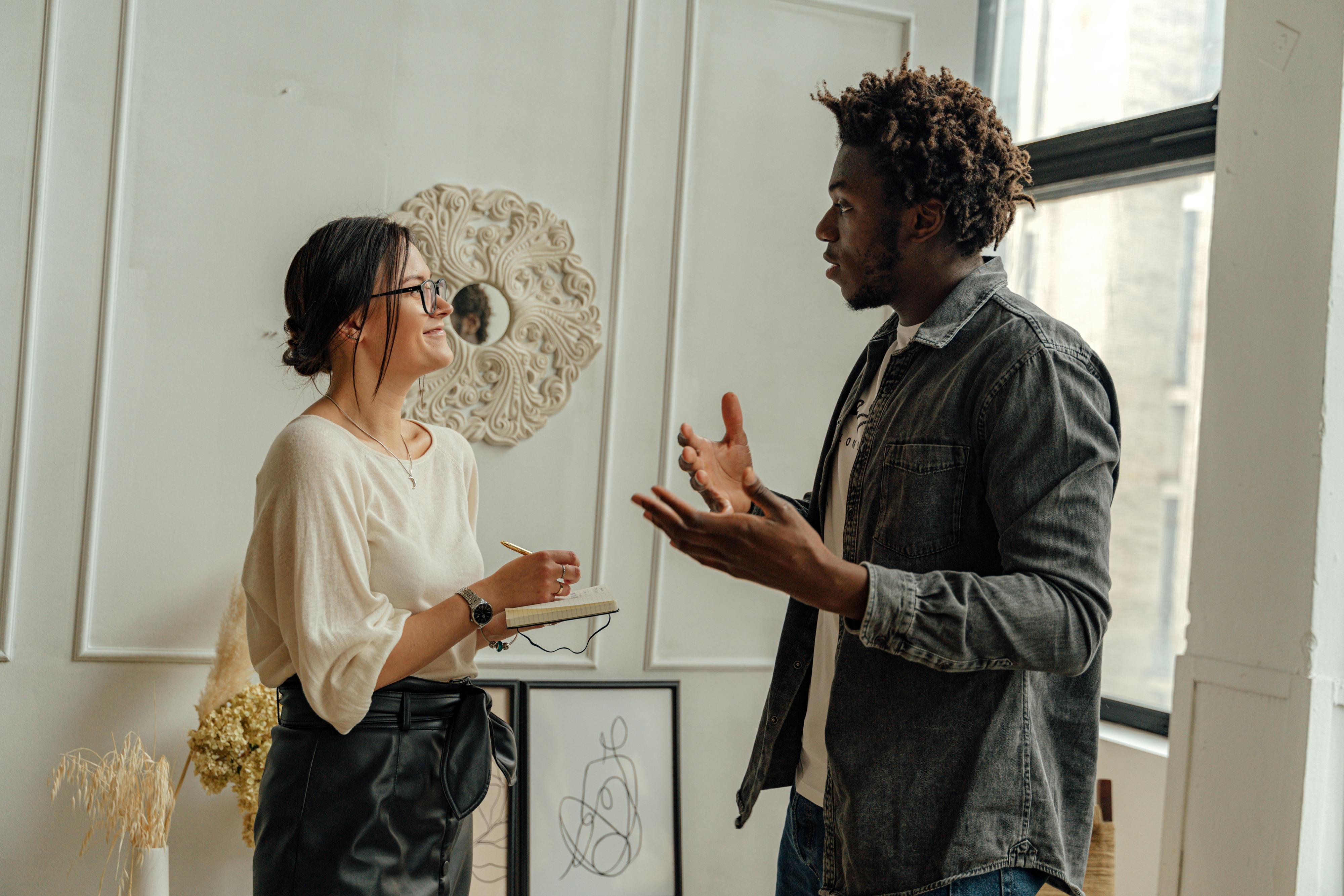 Man in Black Jacket Standing Beside Woman in White Shirt