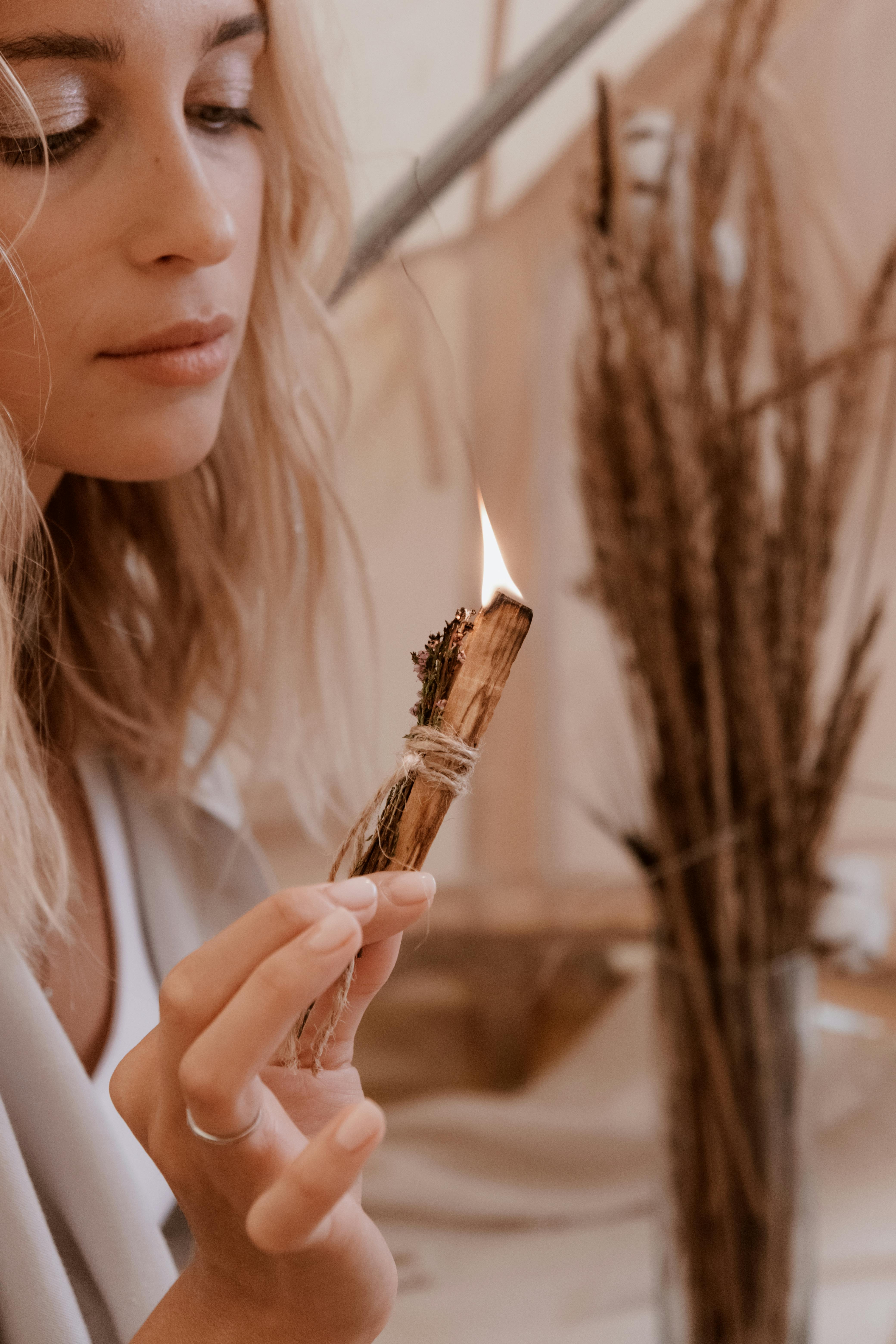 Photo of a Woman Holding a Sage Smudge Stick