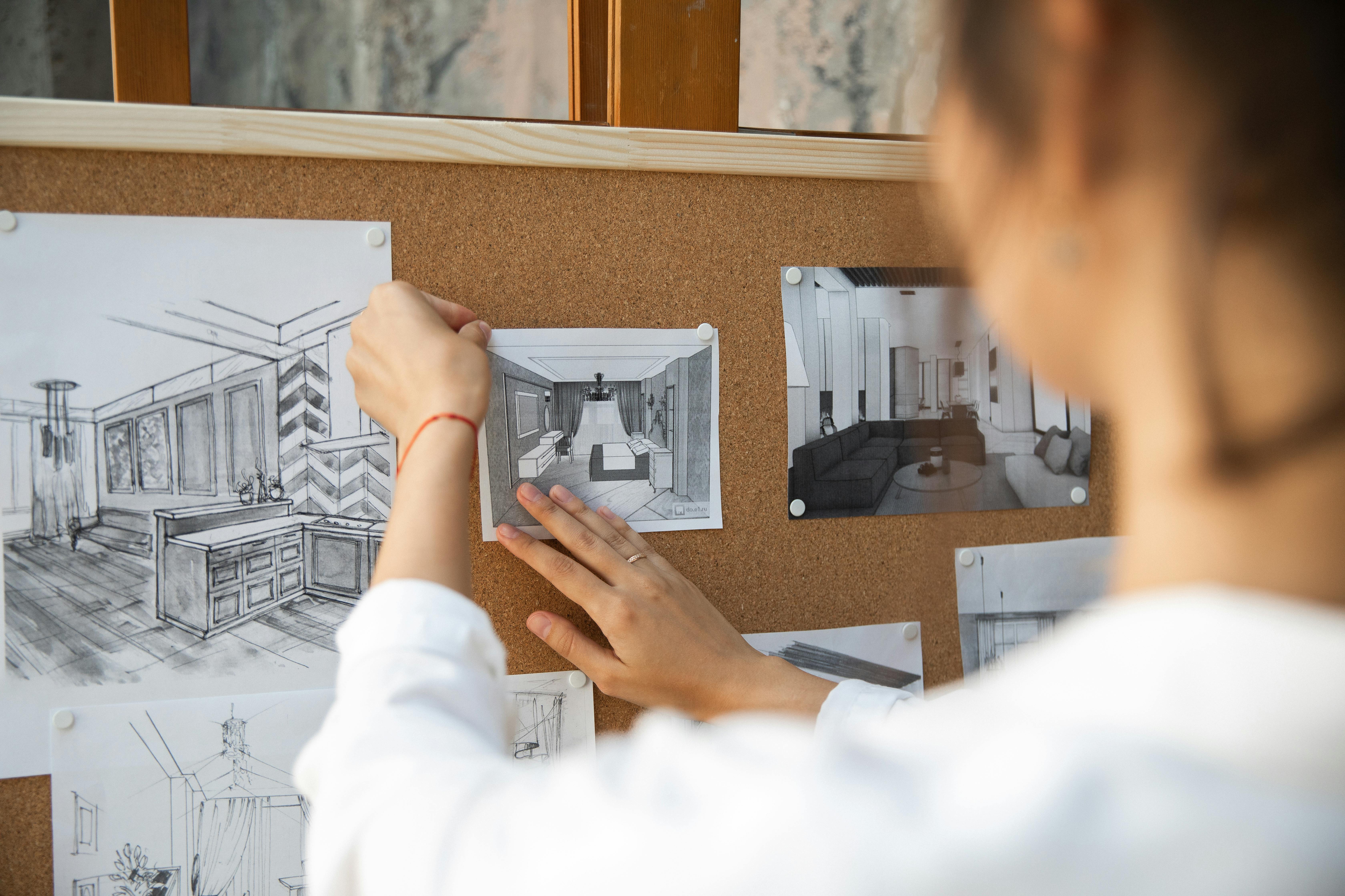 Person Pinning a Paper on a Corkboard