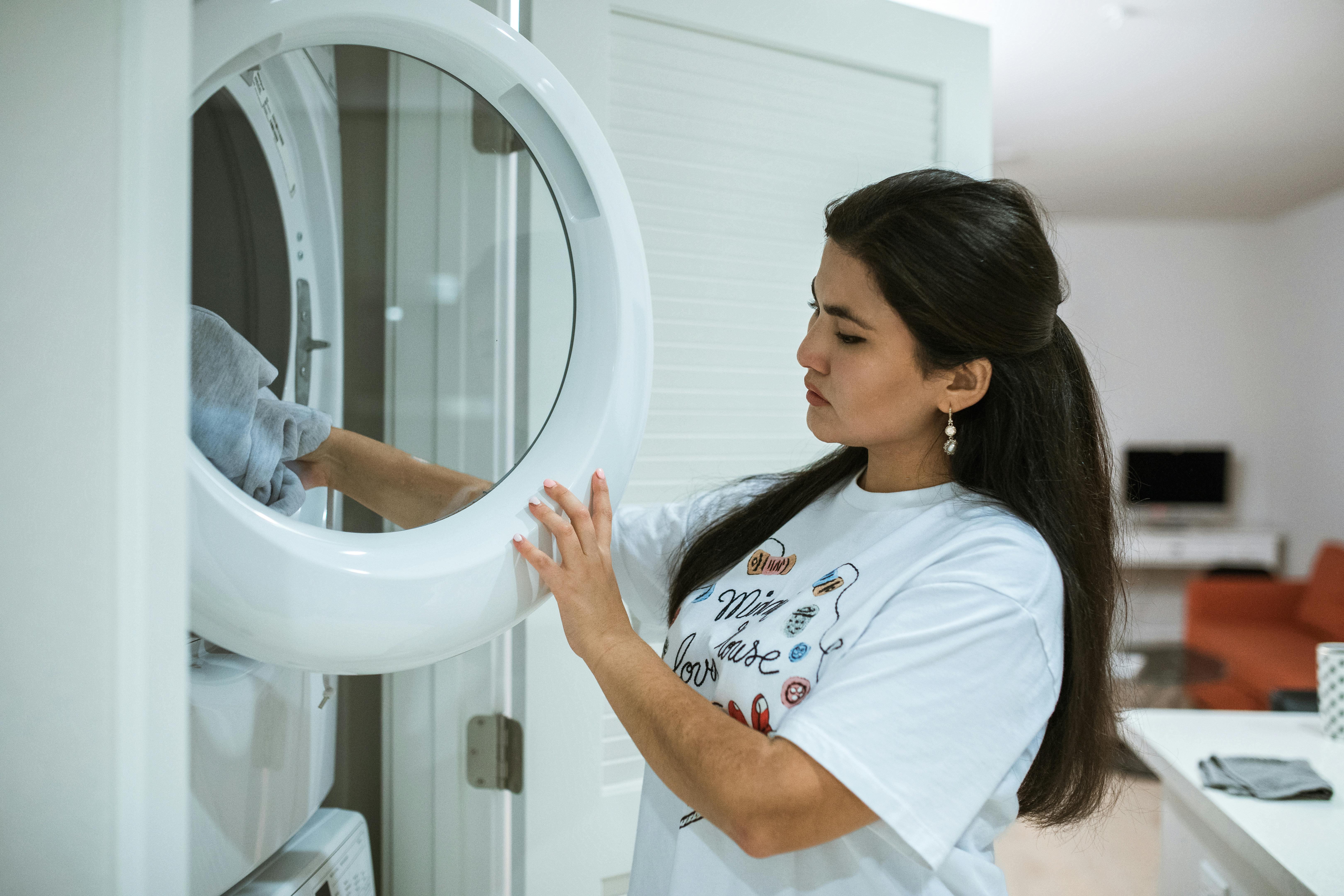 A Woman Wearing a White Shirt Doing a Laundry