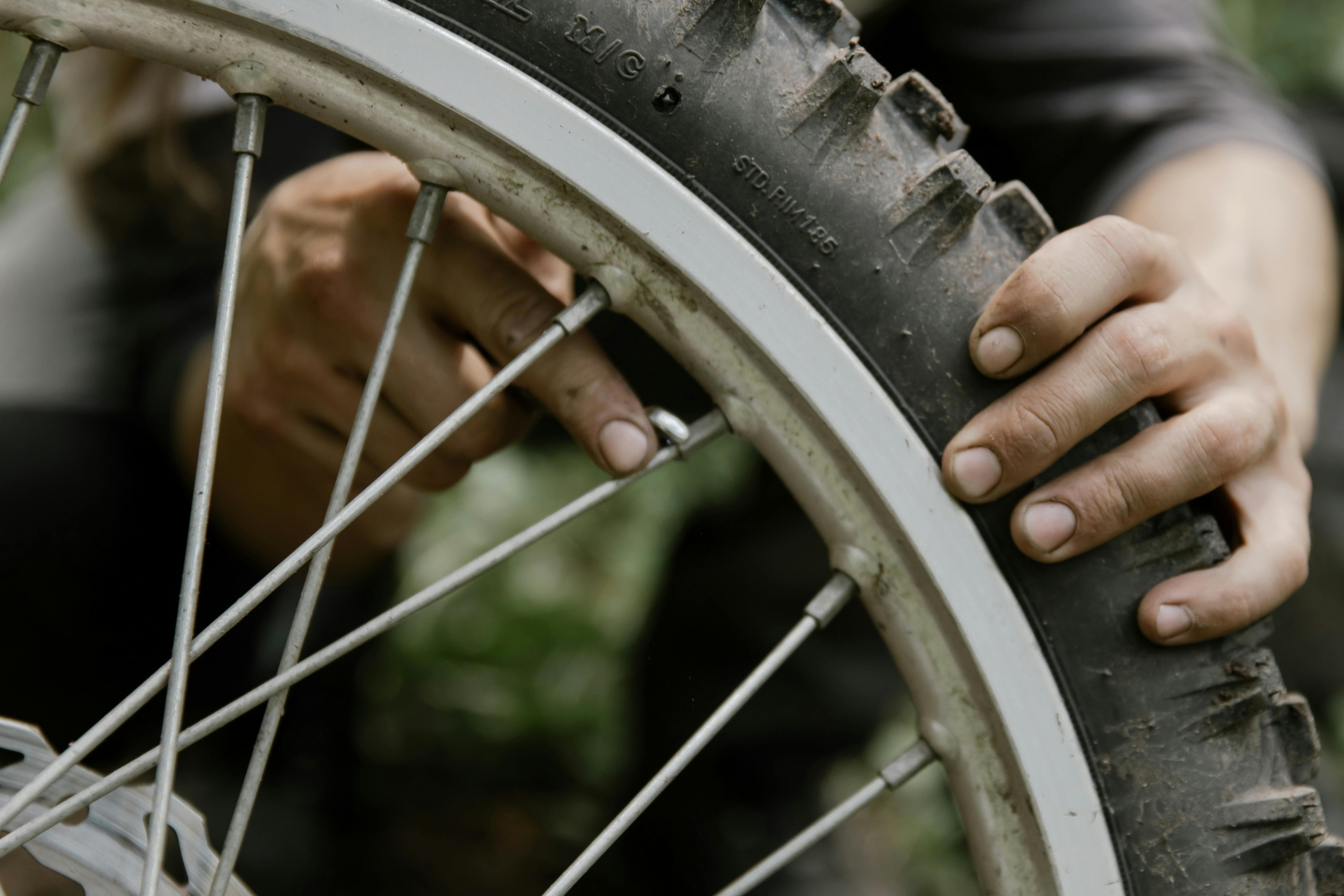A Person Repairing a Motorcycle Wheel