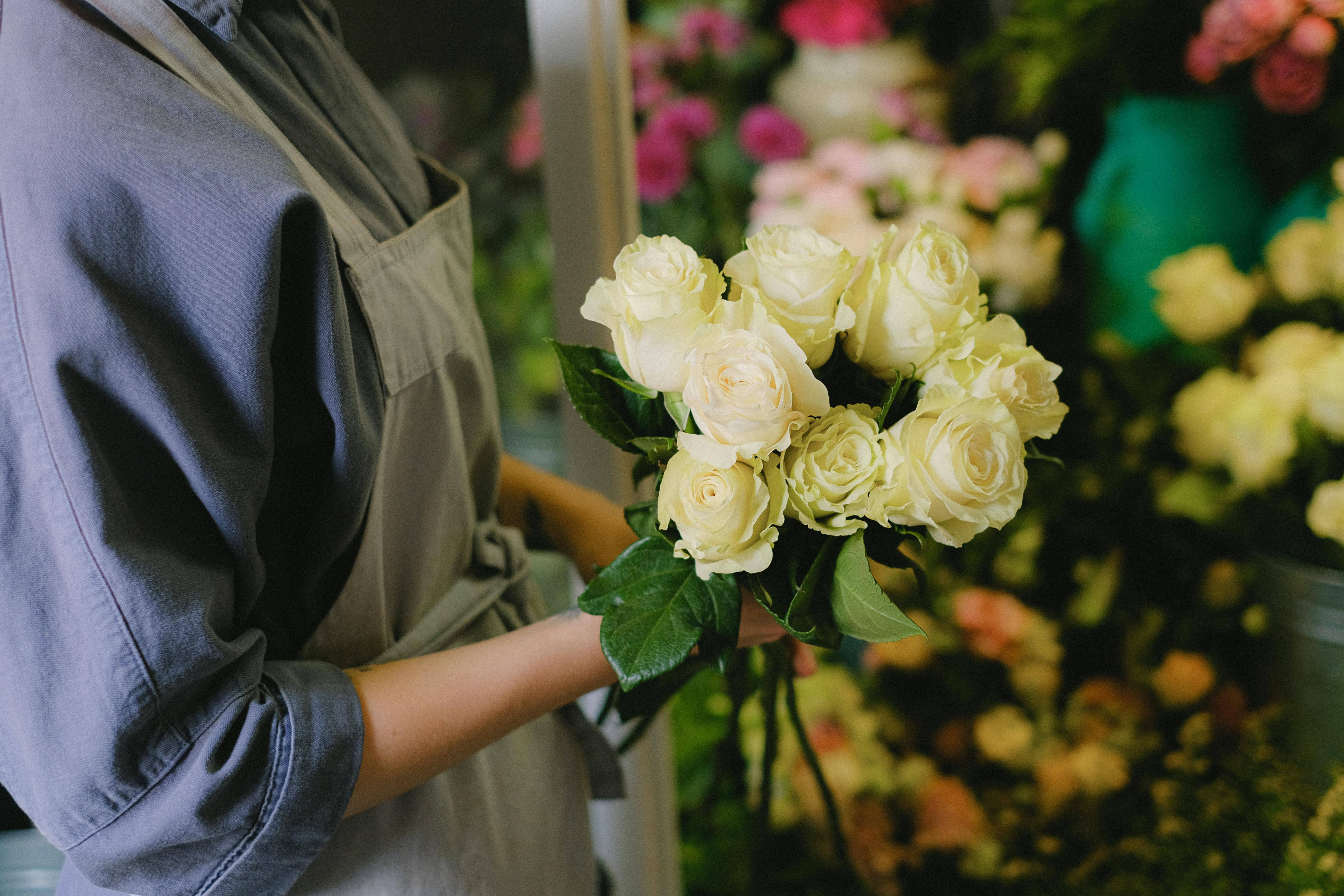 Person Holding White Roses Bouquet