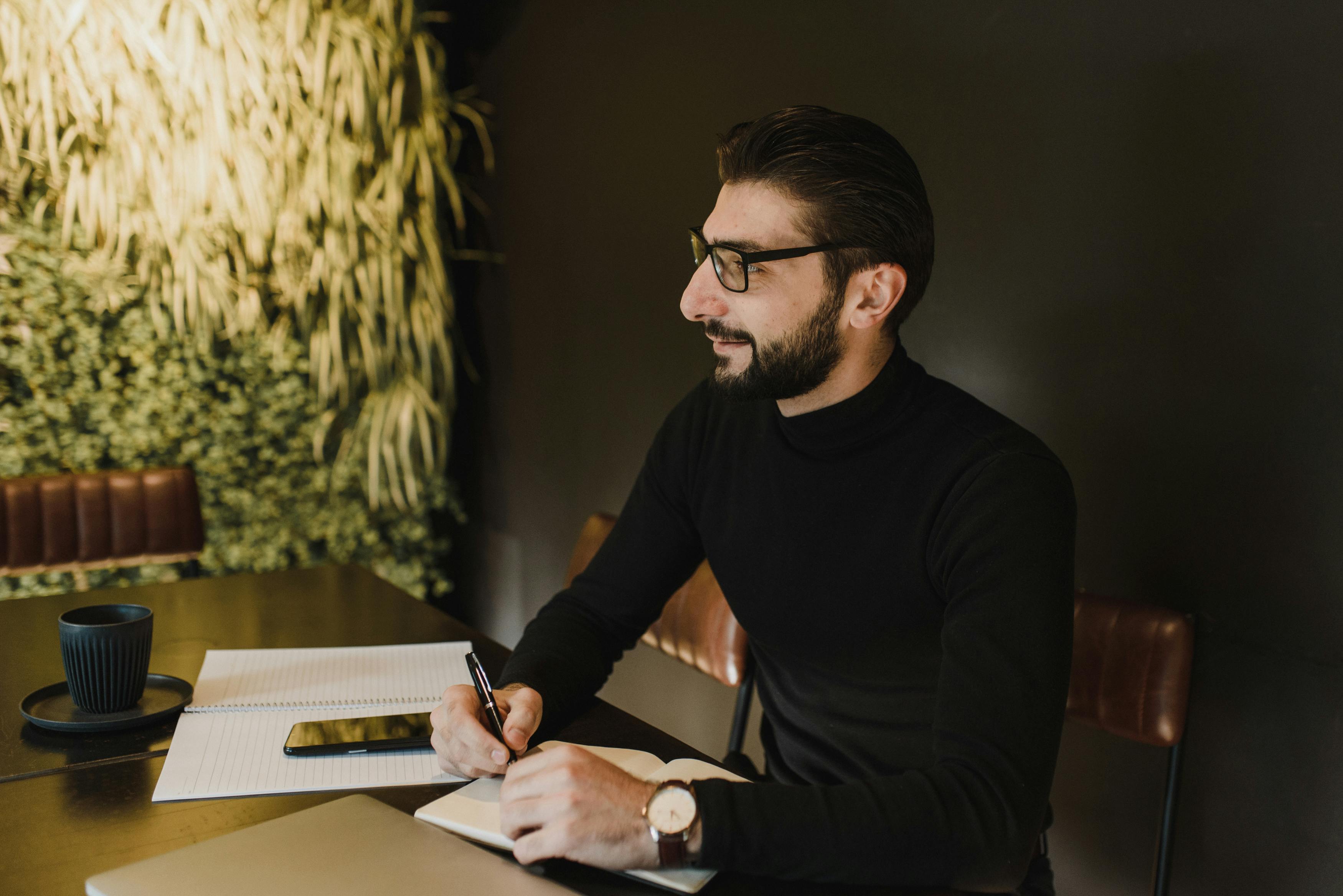 A Man wearing Eyeglasses holding a Pen