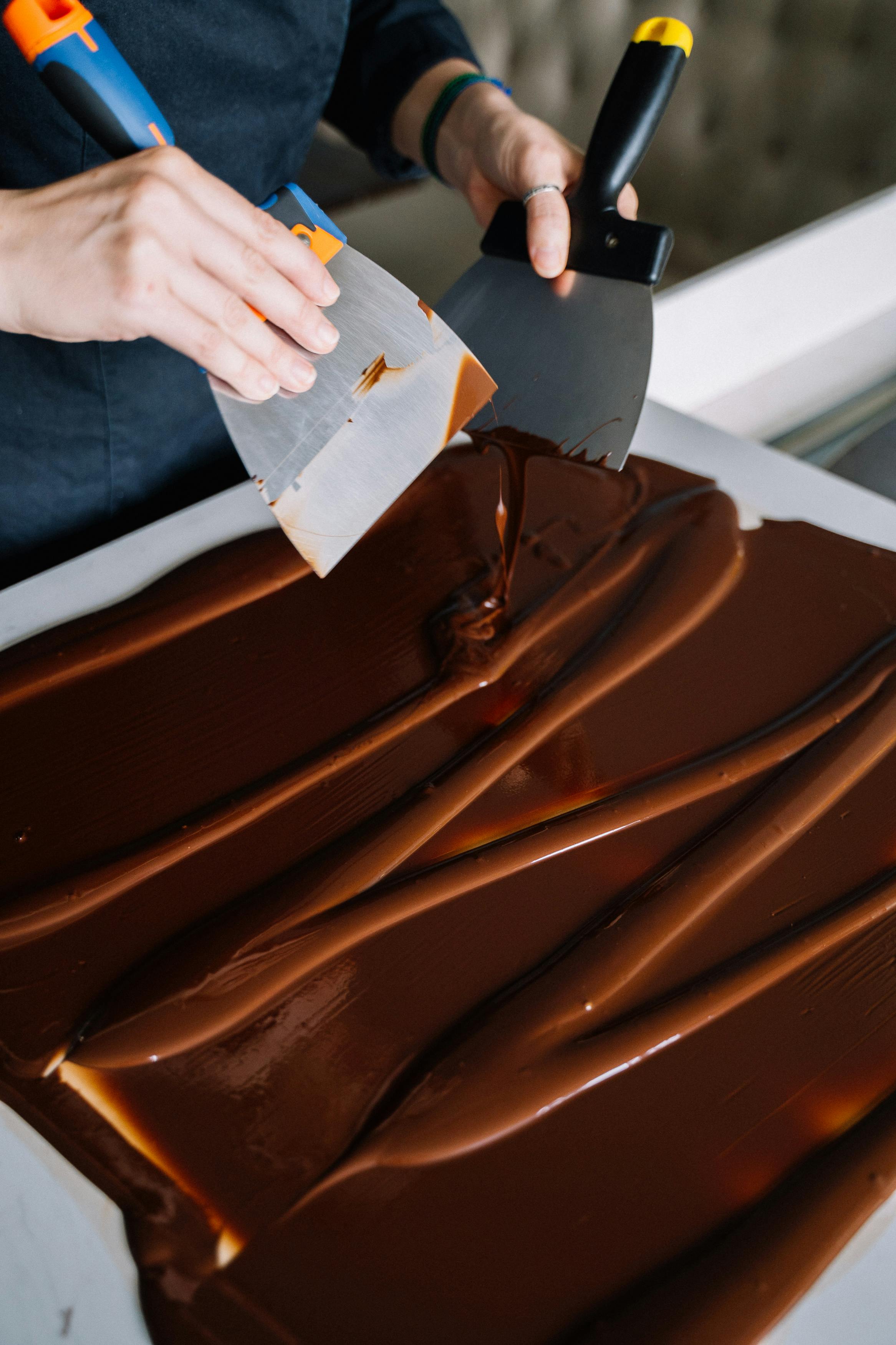 Liquid Chocolate Spread on a Baking Paper Using Spatulas