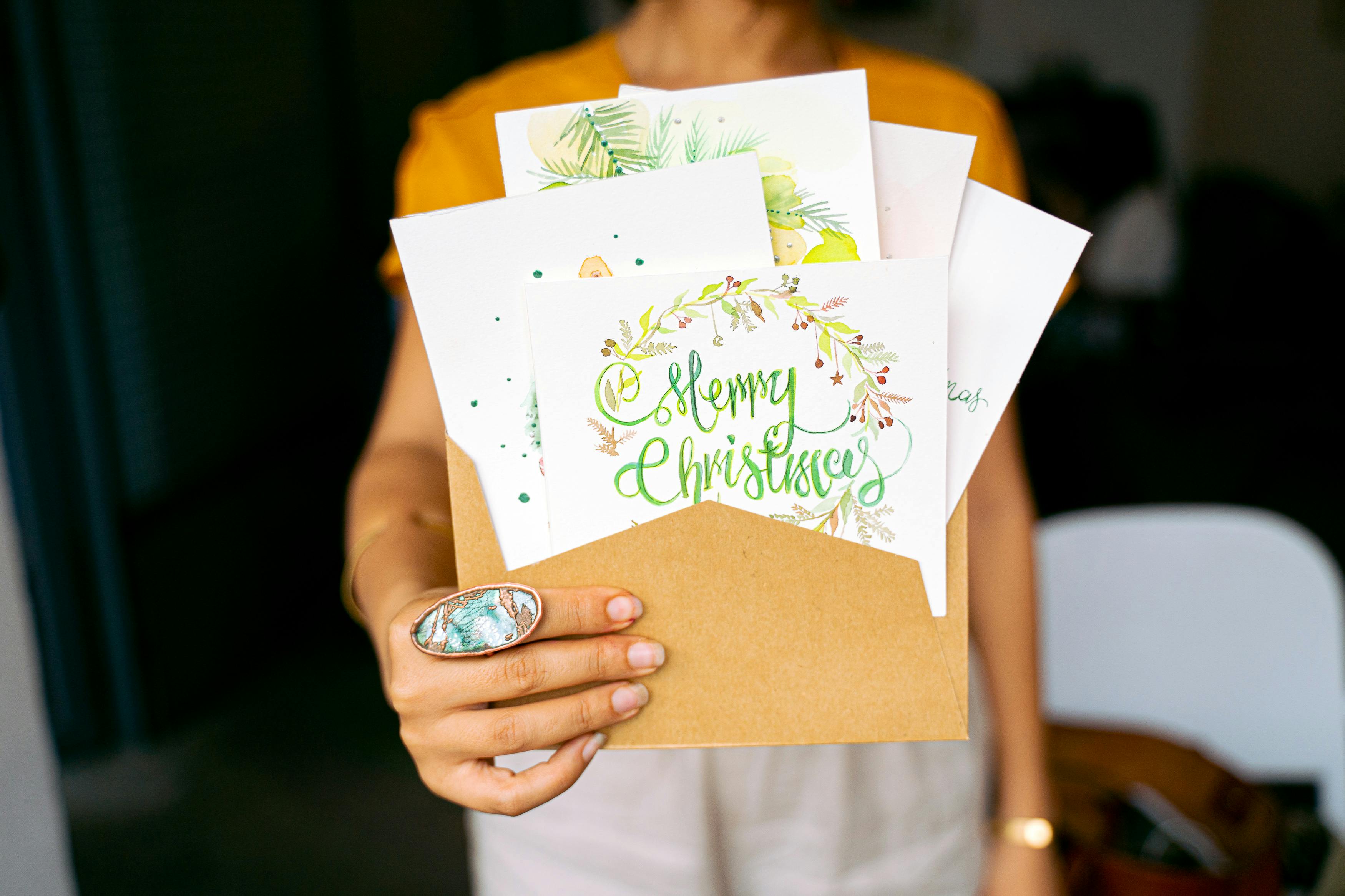 Close-Up Shot of a Person Holding Christmas Cards