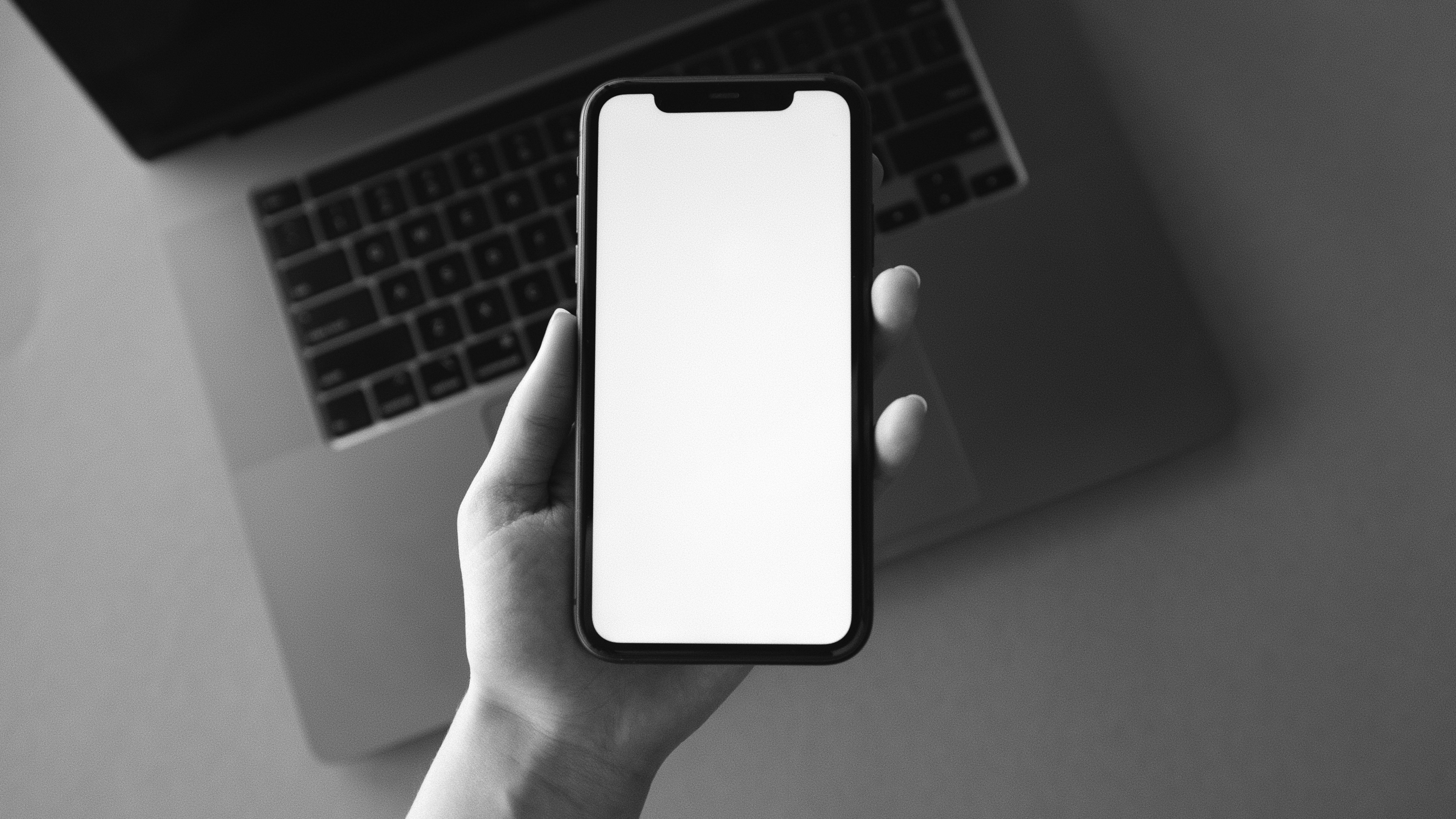 Person Holding Iphone with Blank Screen 