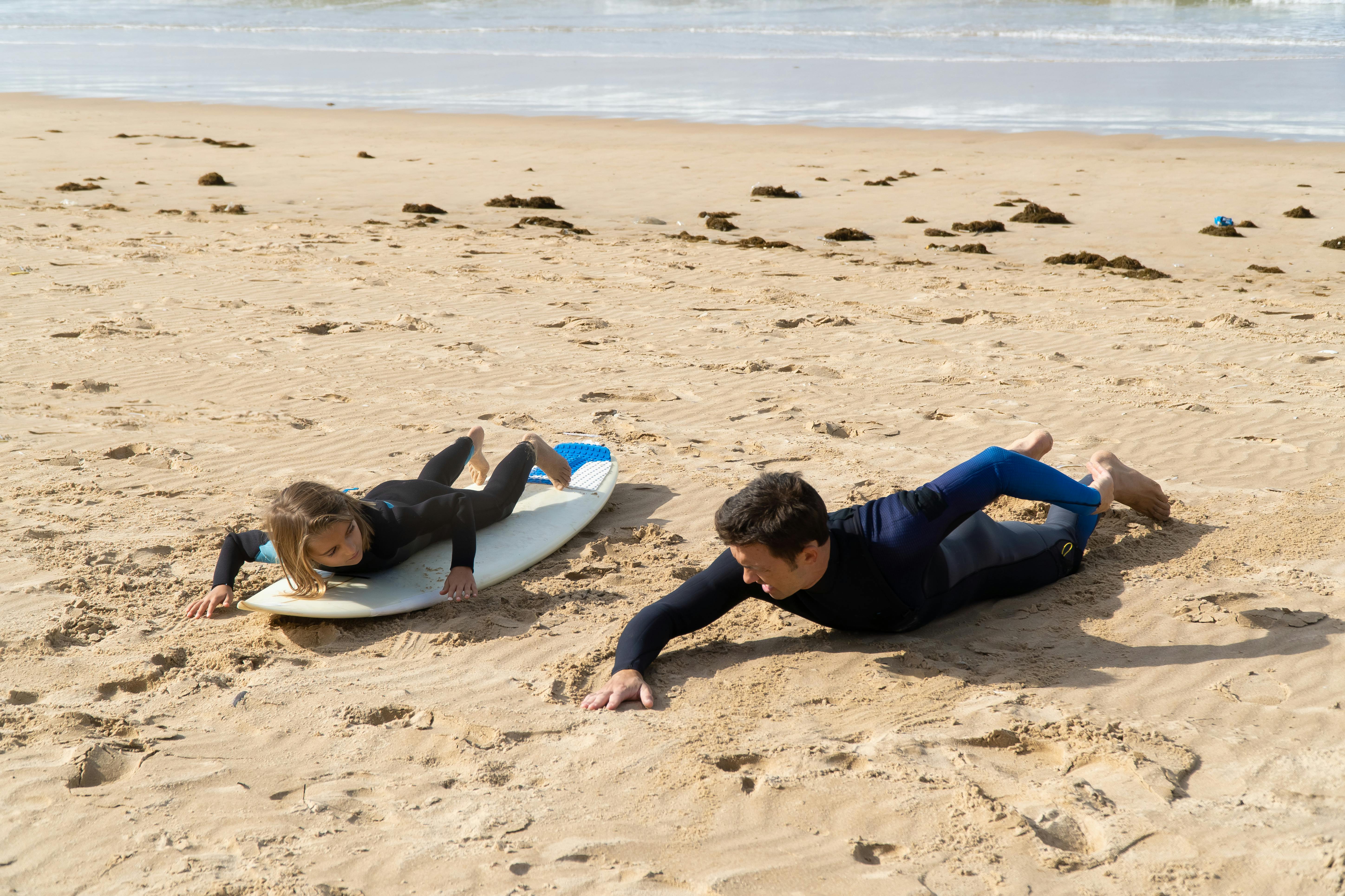 A Man Giving Surfing Lesson to a Girl