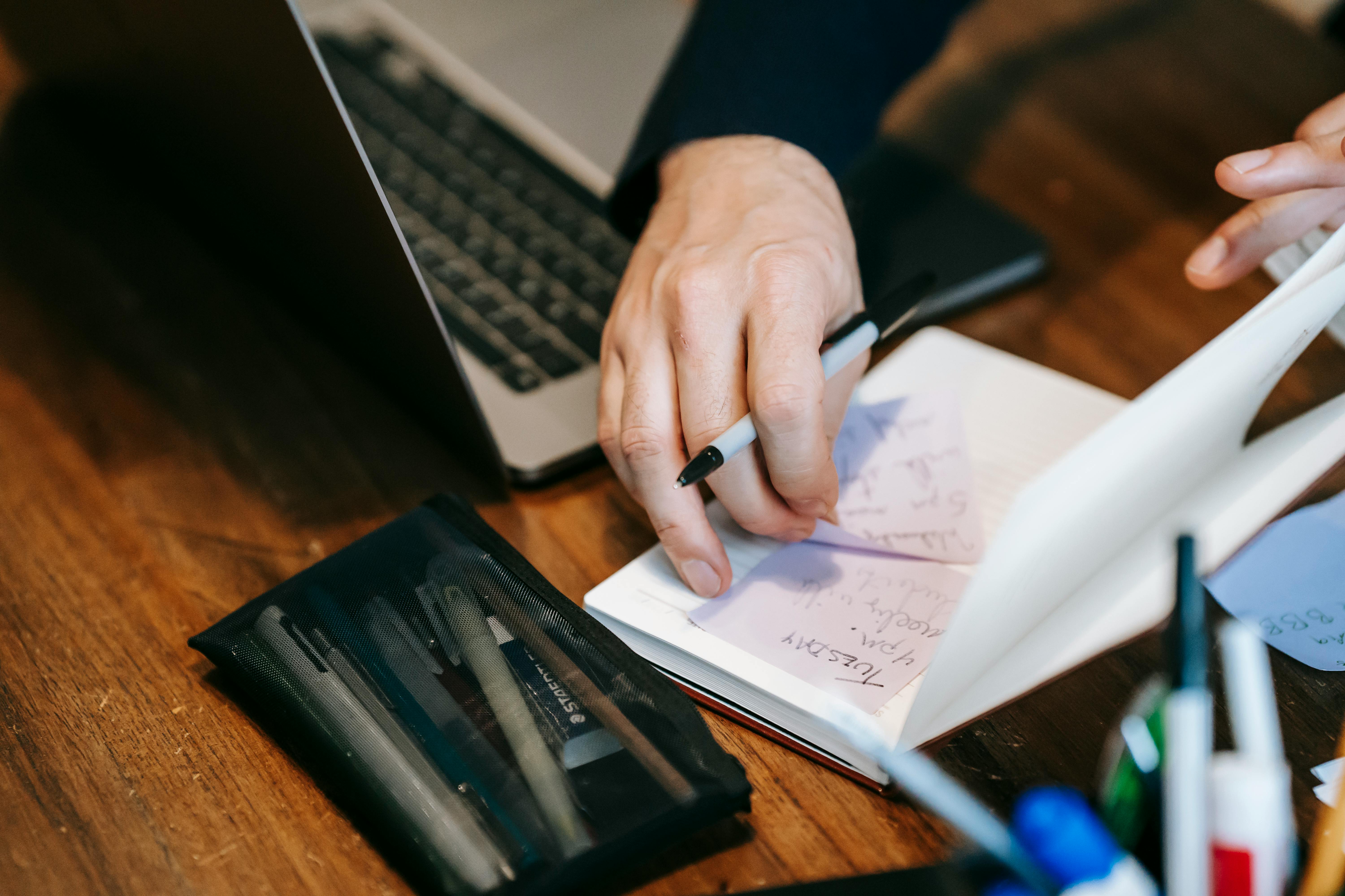 Photo Of Person Writing On White Paper