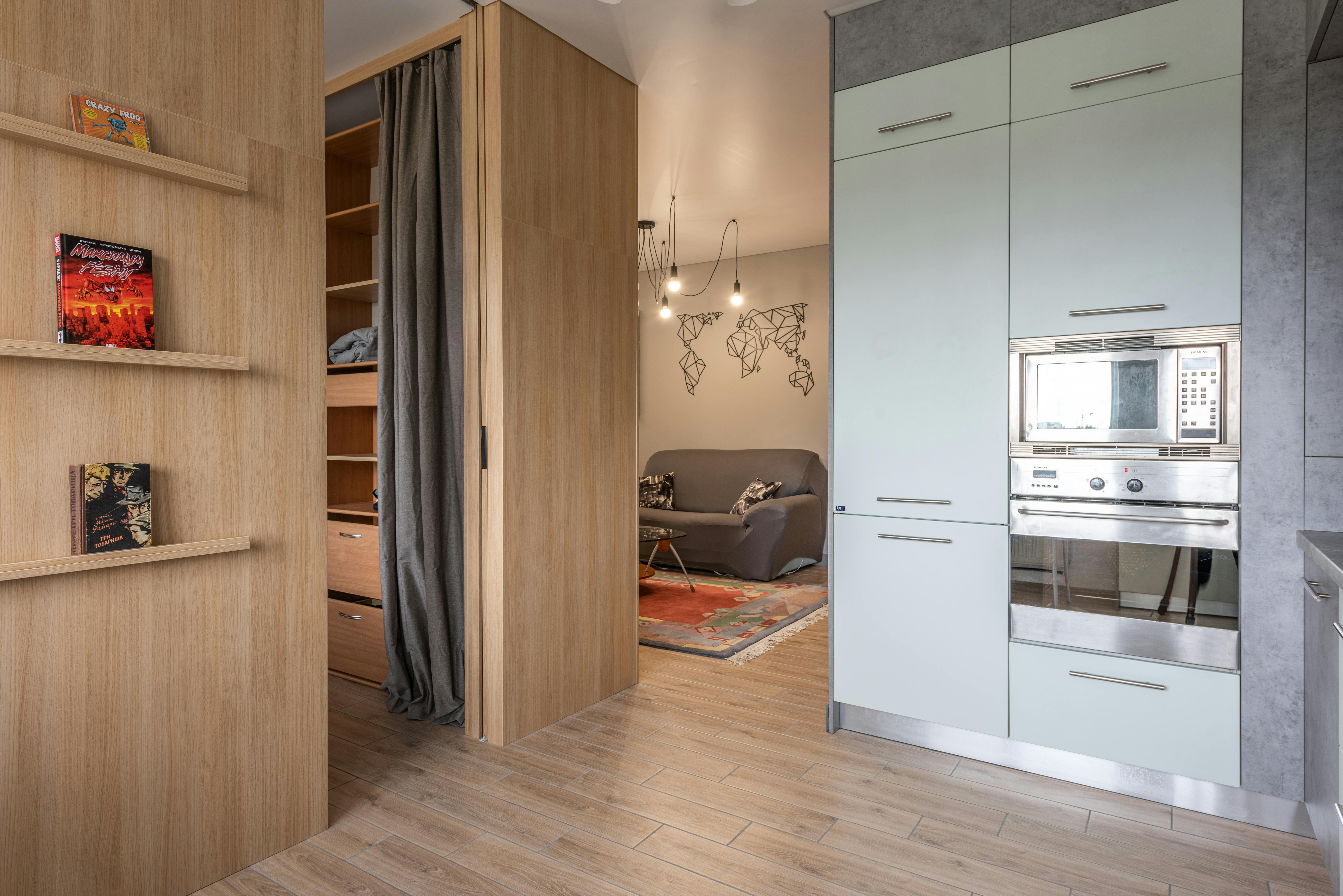 House with cupboards in kitchen near bookshelves and living room