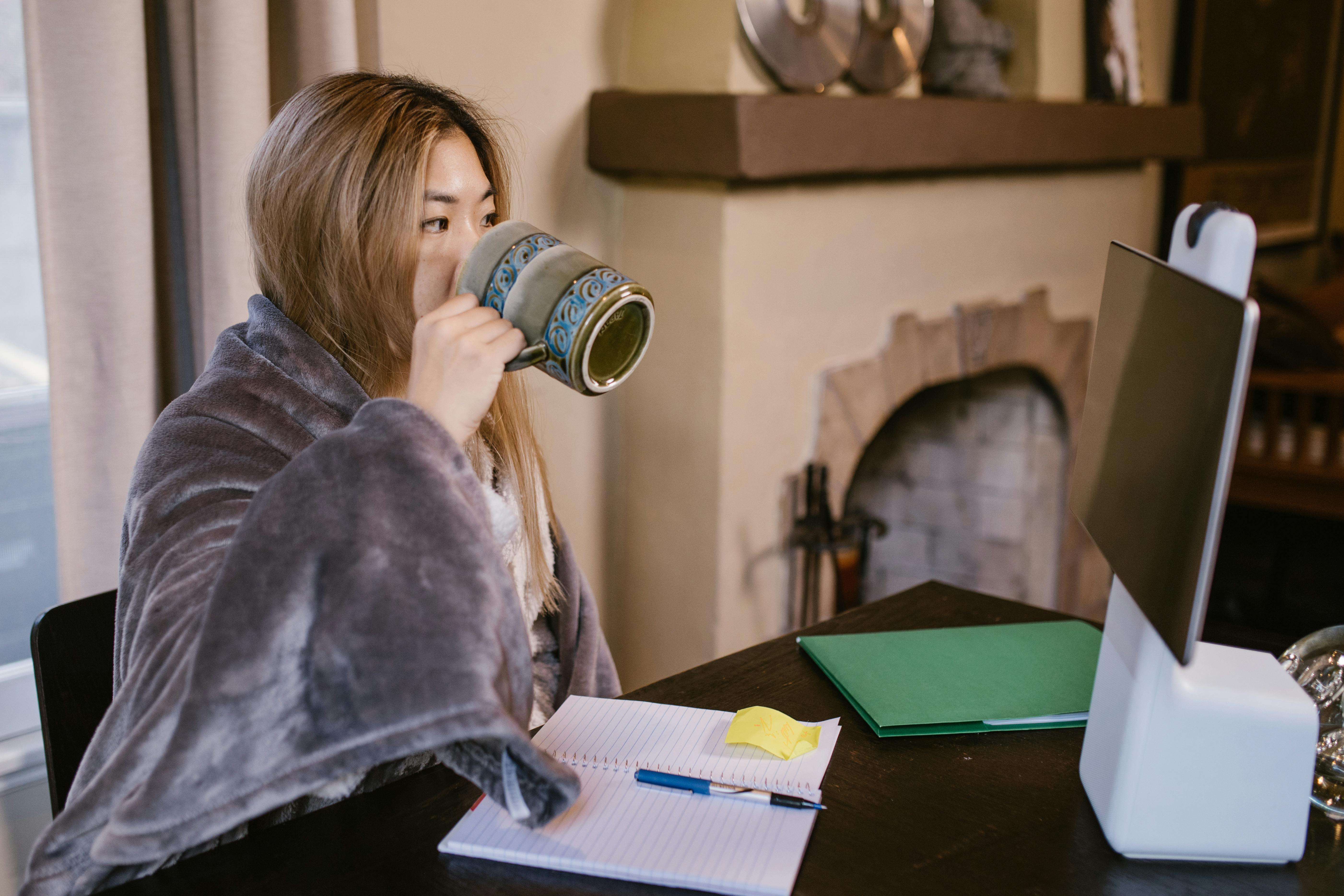 Woman in Blue Denim Jacket Drinking from White Ceramic Mug