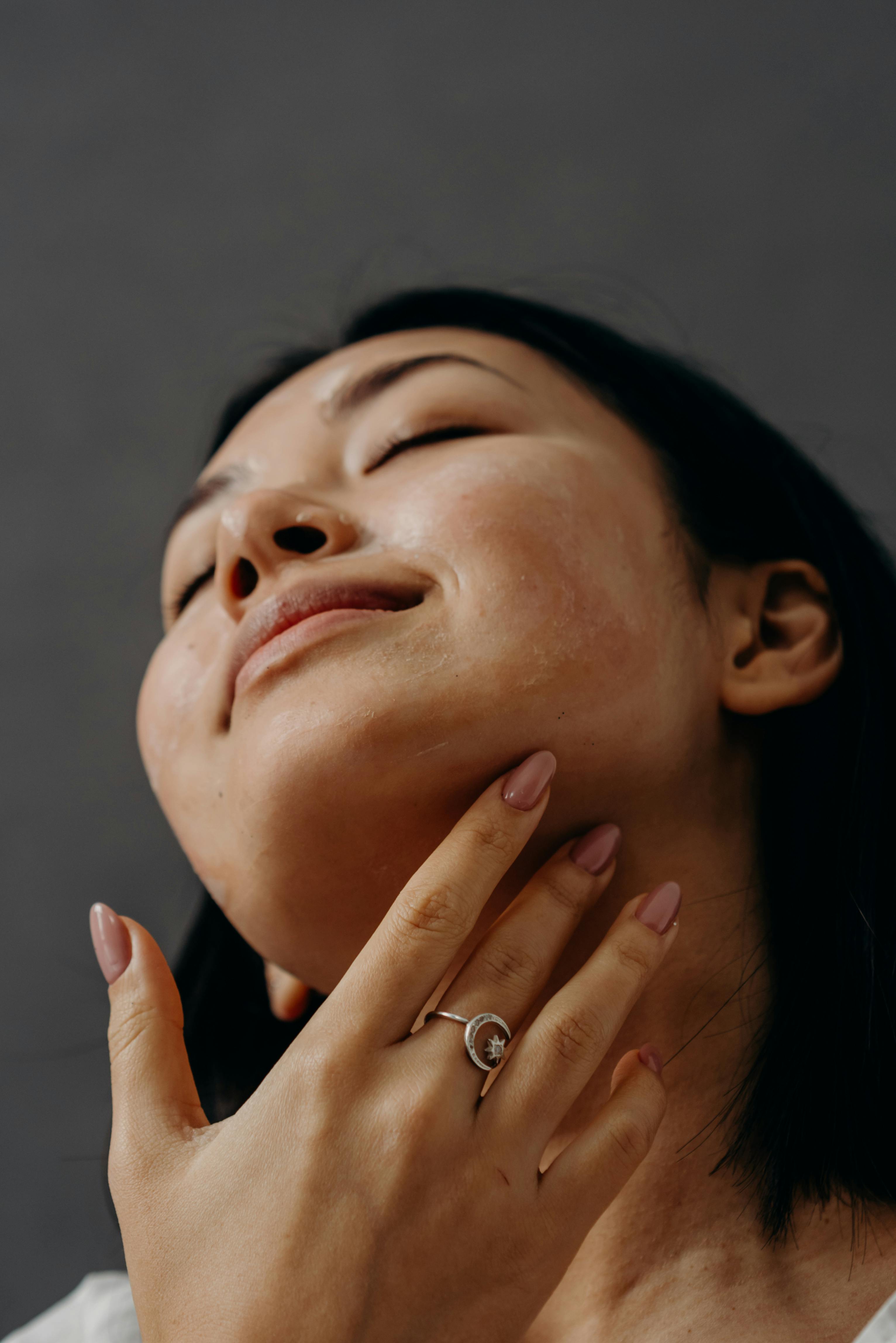 A Woman Touching Her Neck with Her Eyes Closed