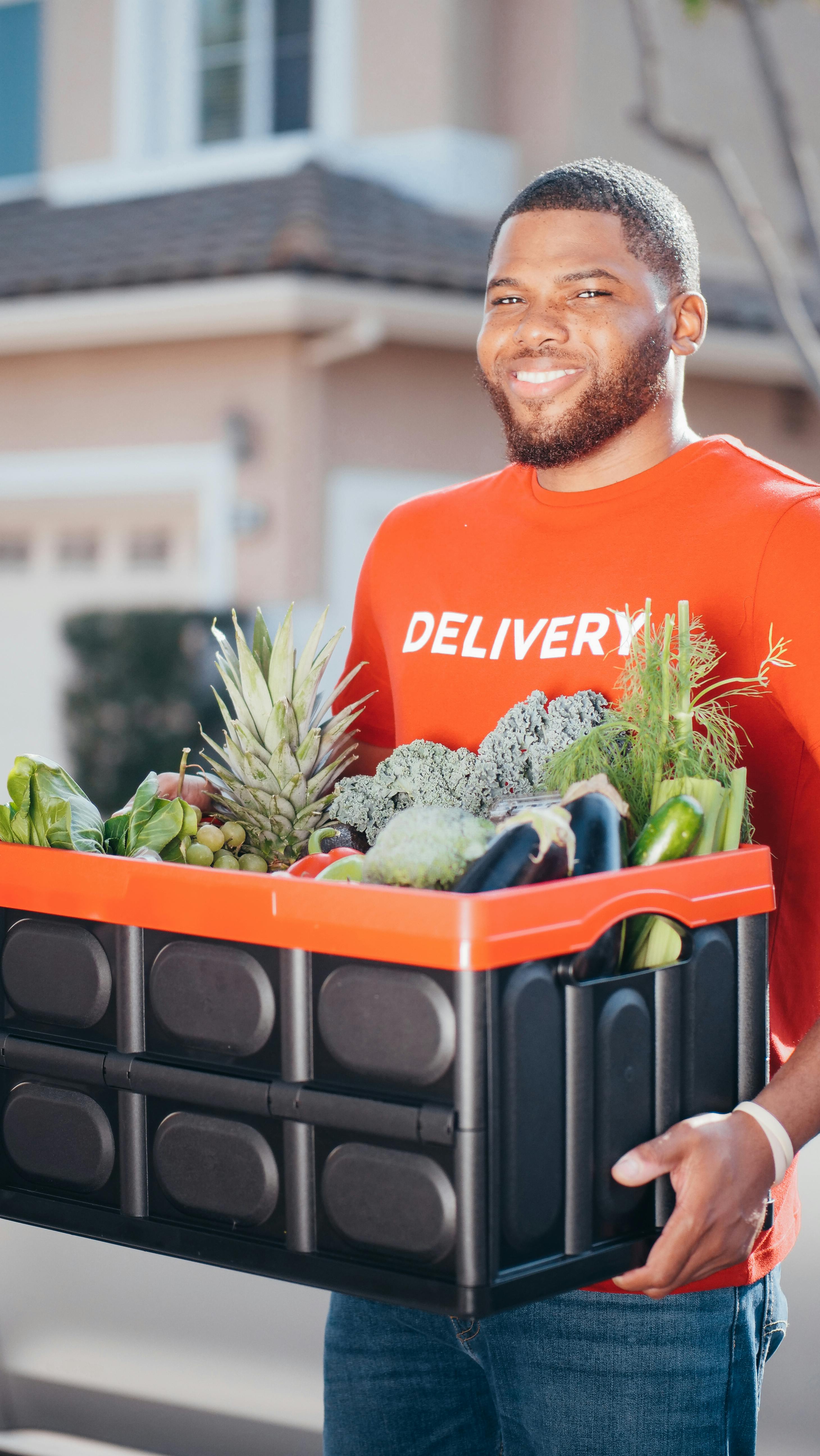 Man in Red Crew Neck T-shirt Holding a Crate of Fresh Vegetable