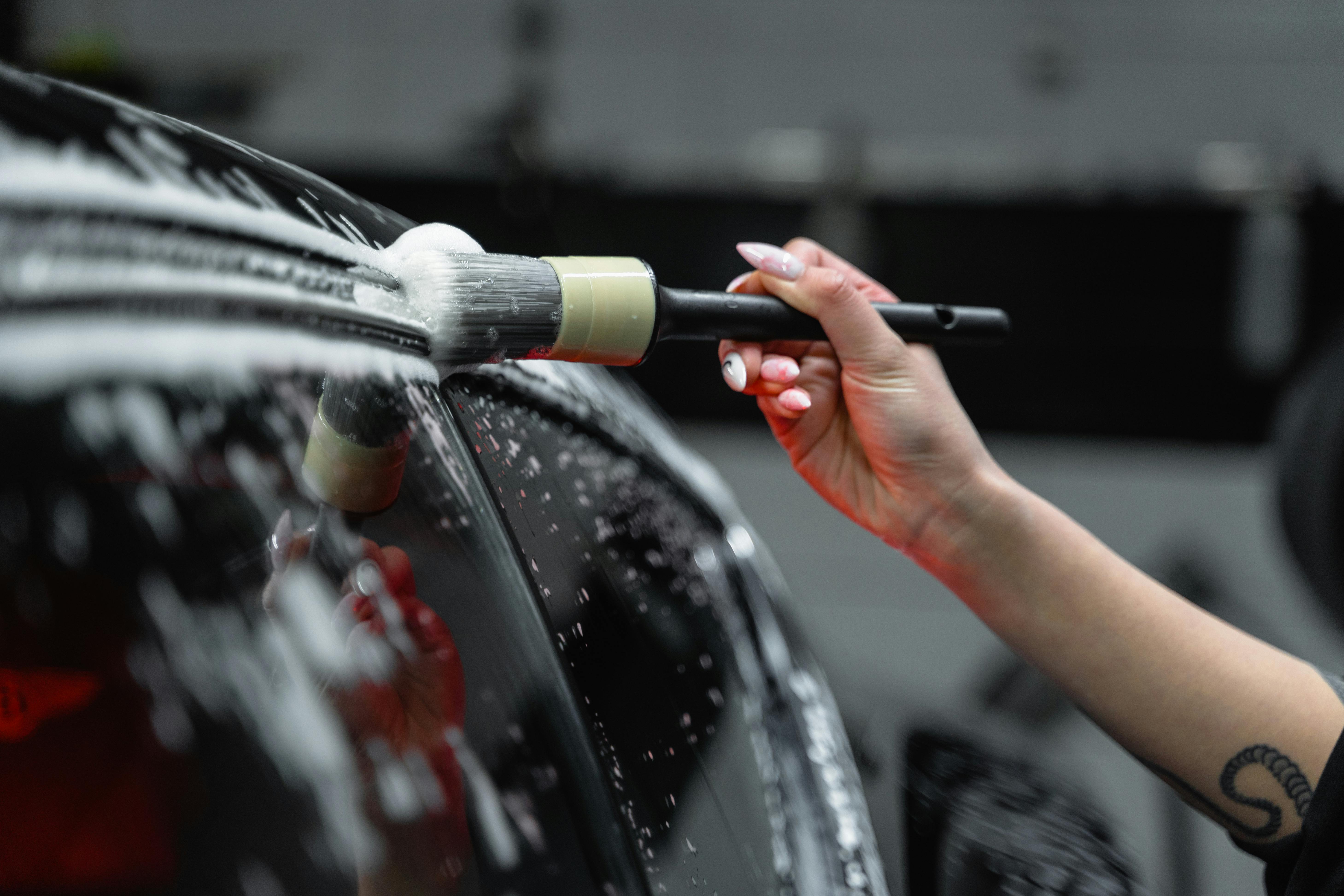 A Close-Up Shot of a Person Brushing a Car