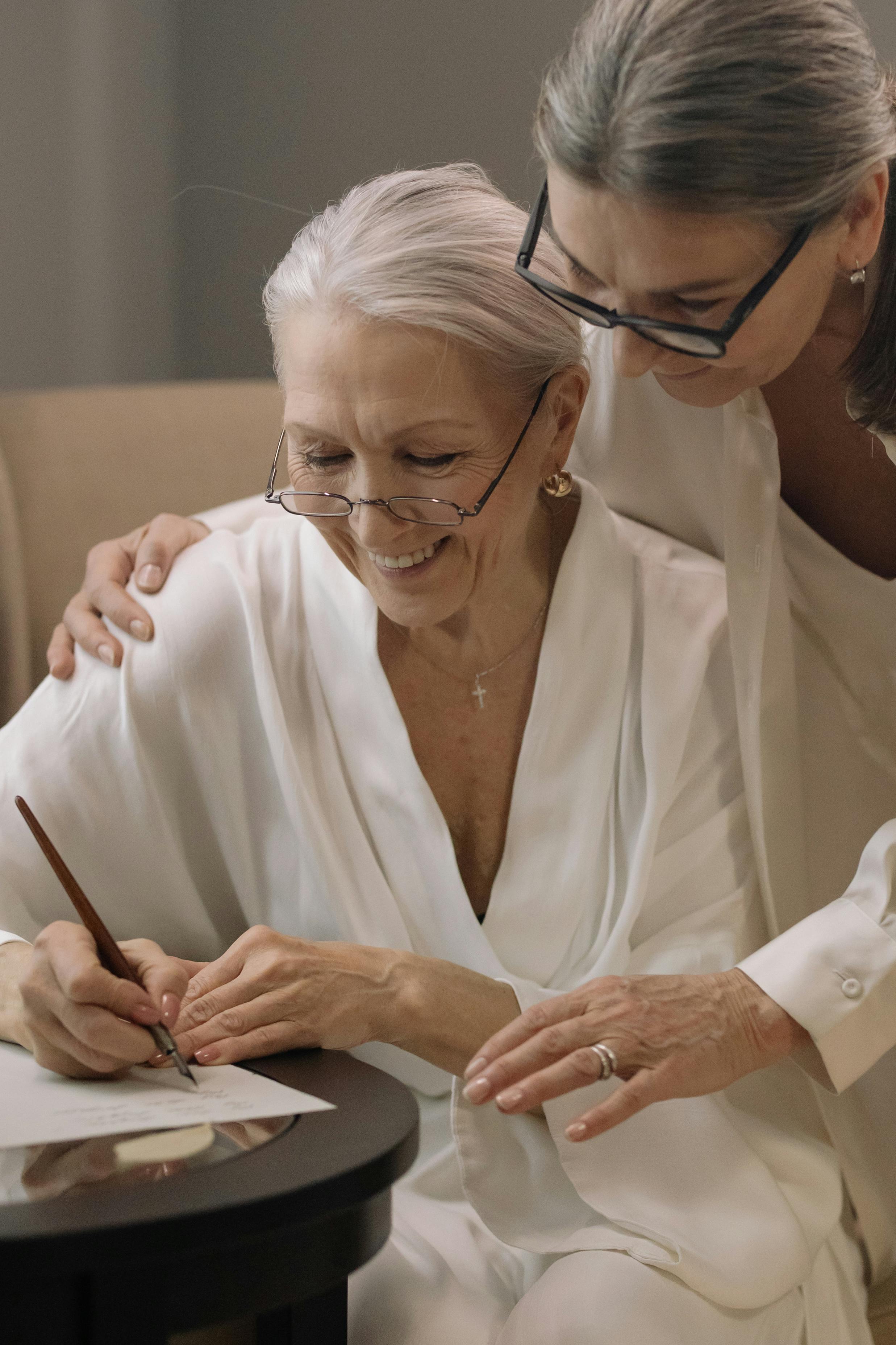 A Woman in White Robe Writing on the White Paper