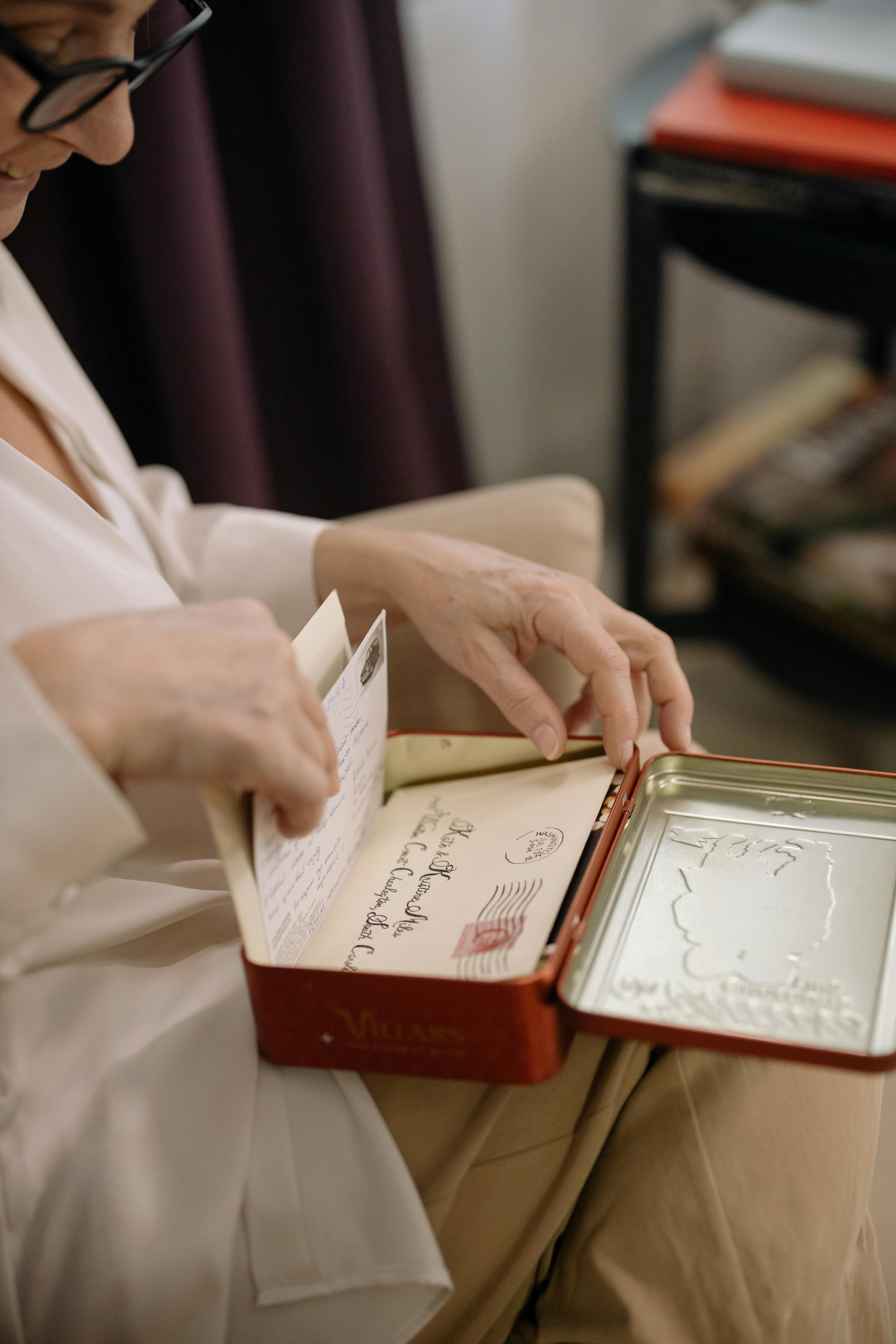 A Person Holding a Tin Can Box with Letters