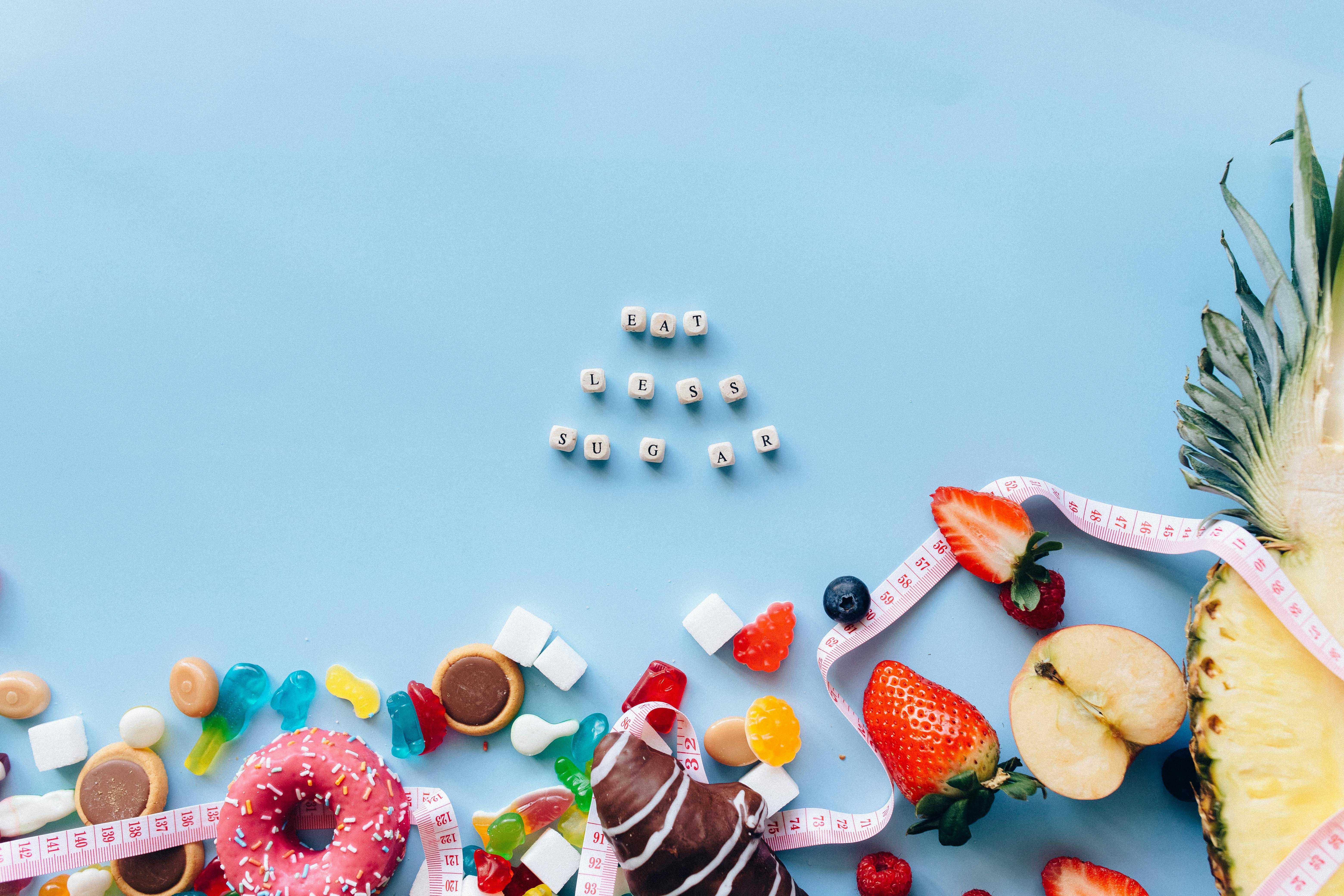 Letter Dice with Message Above Assorted Candies and Chocolates on a Blue Surface